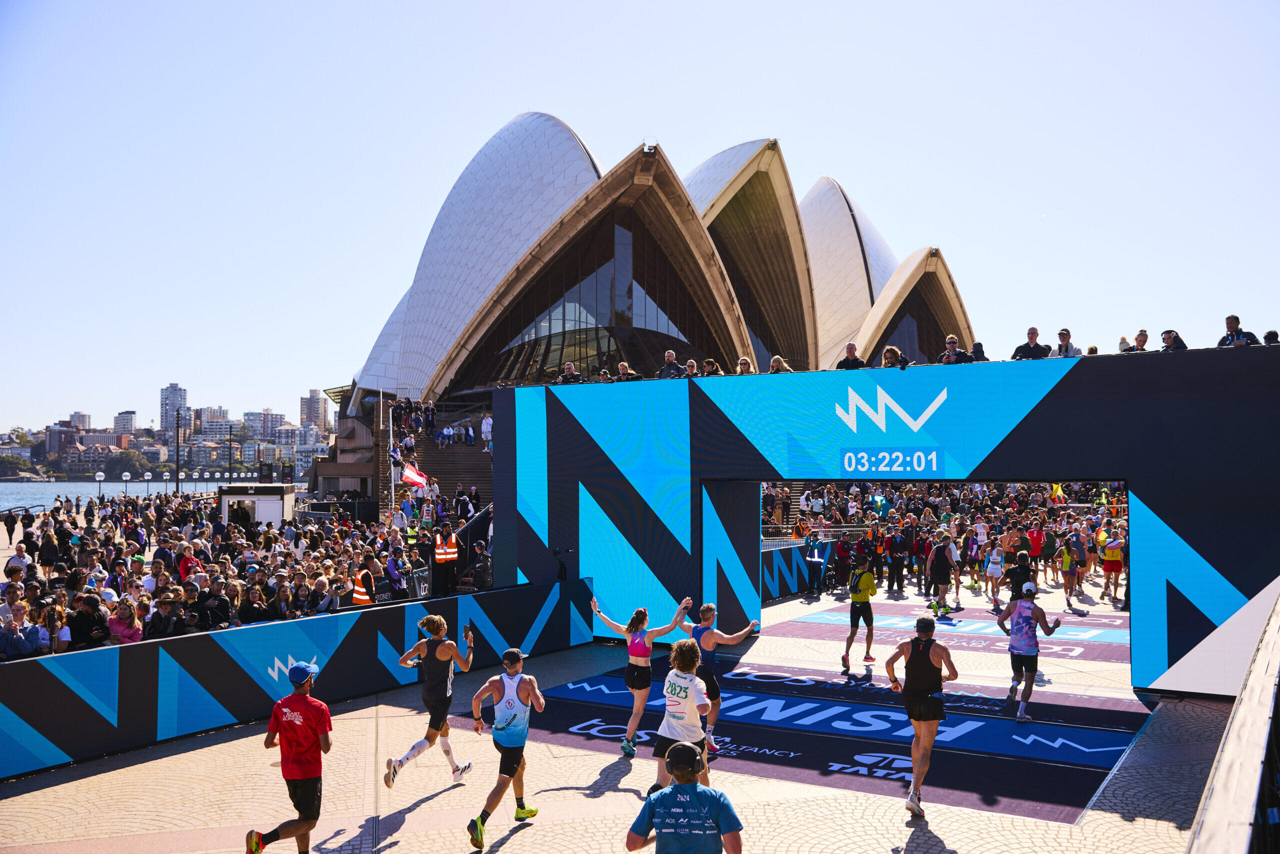 Sydney Marathon runners at the finish line in front of the Sydney Opera House