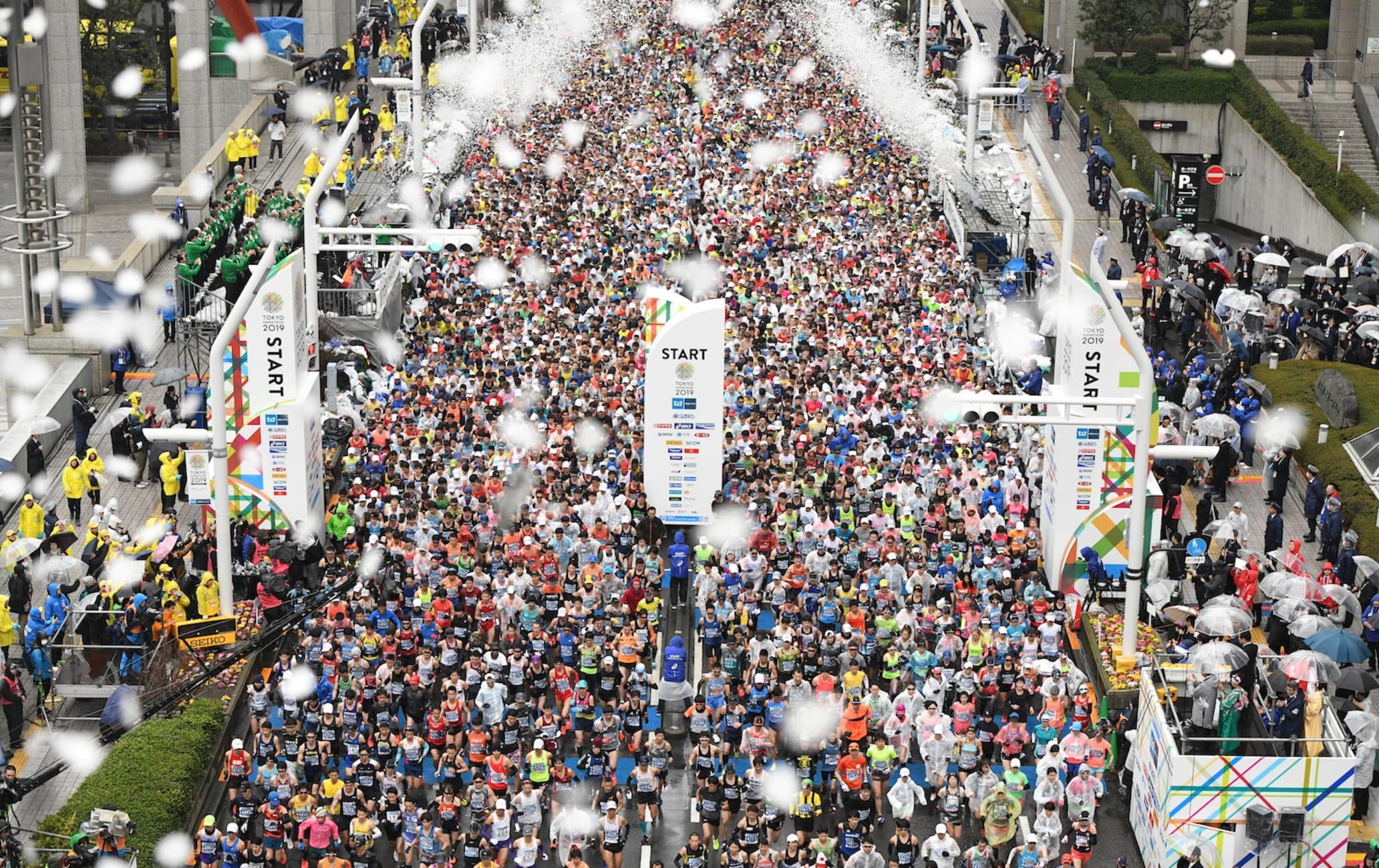 Tokyo Marathon start line with hundreds of runners and confetti