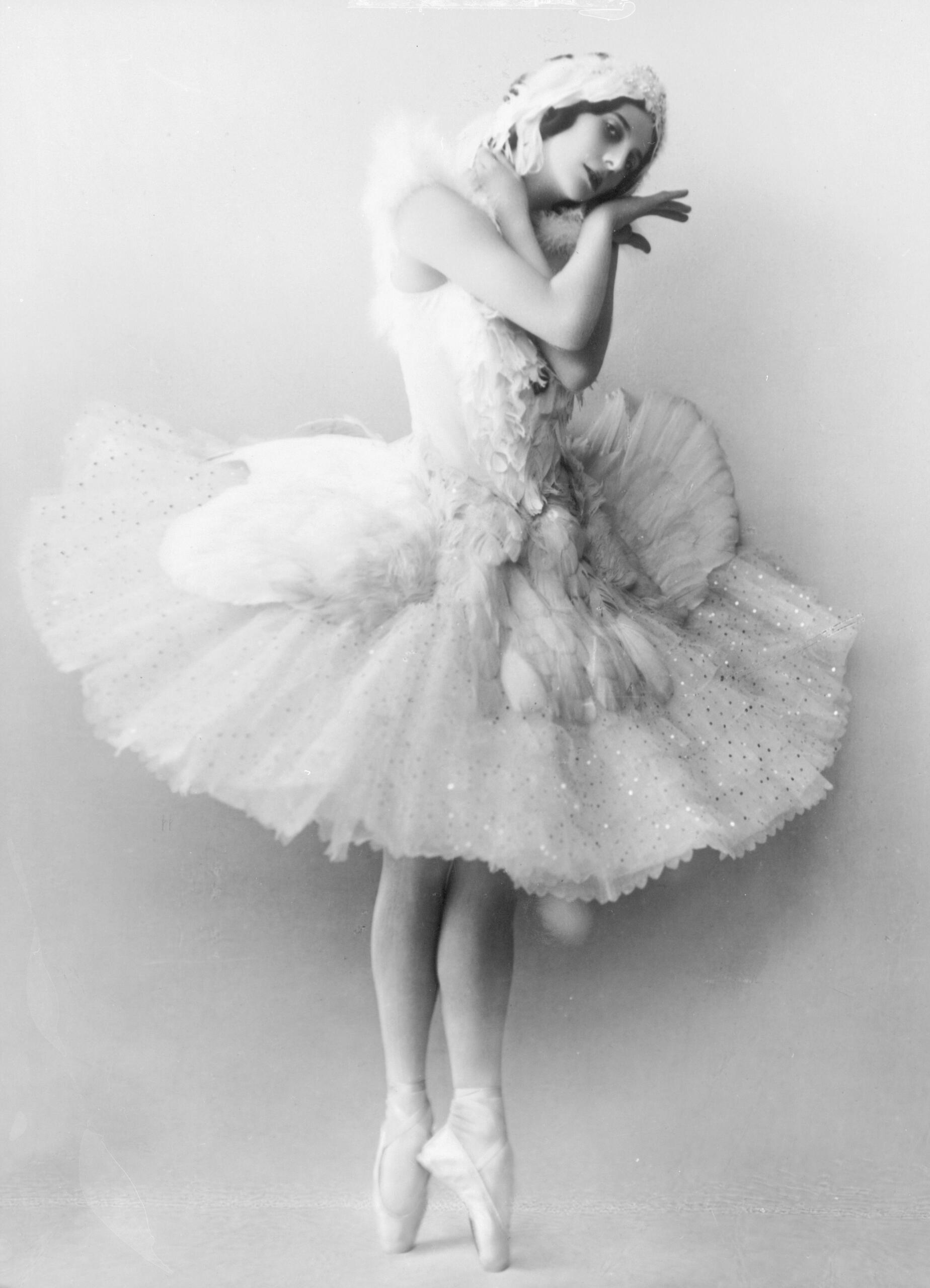Anna Pavlova in a dance costume posing on pointe shoes.