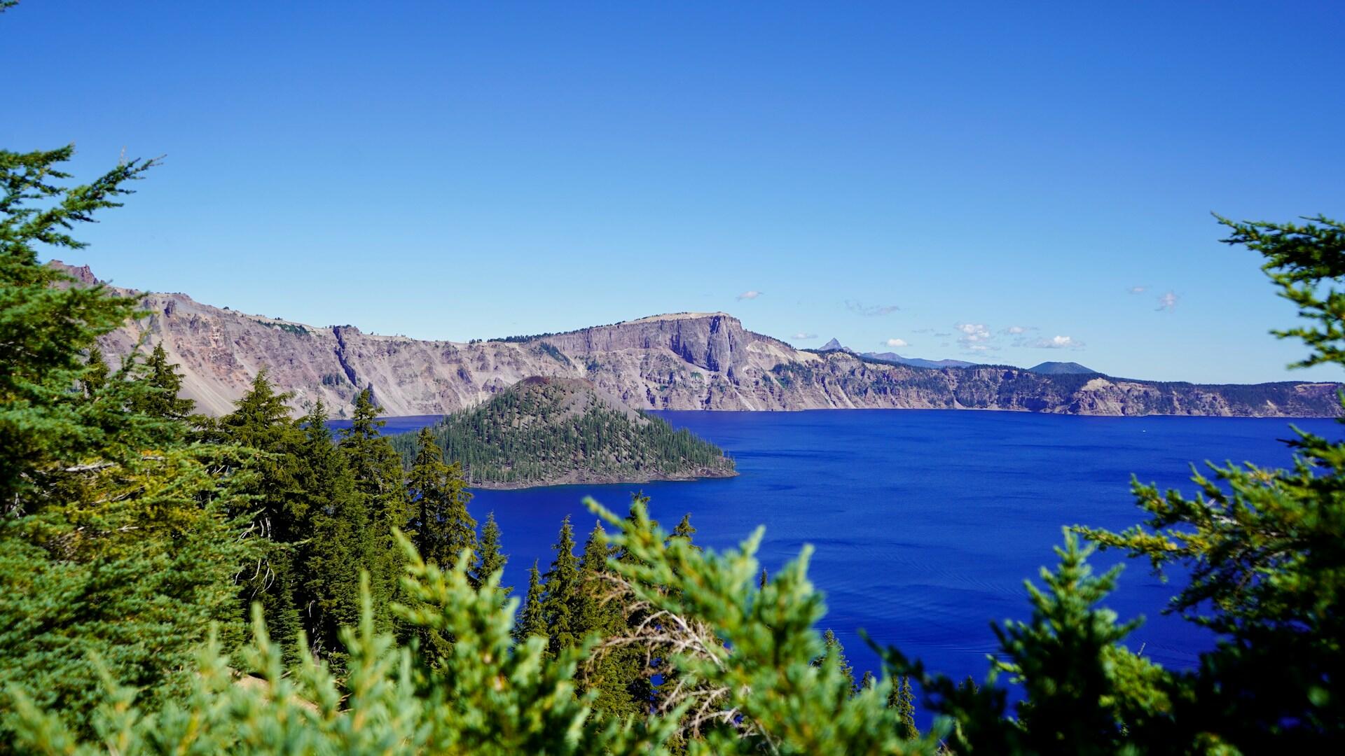 Crater Lake with Wizard Island in the middle. The water is an extreme cobalt blue color