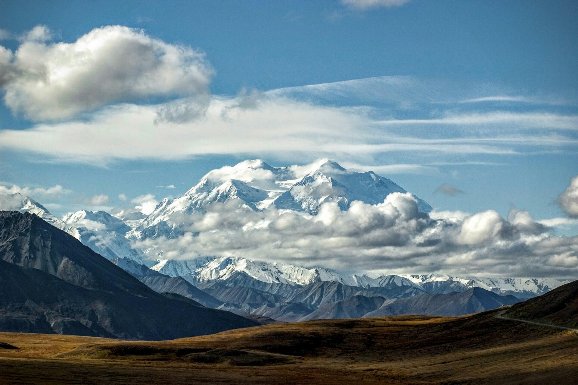 Denali rising into the sky with low clouds around the base