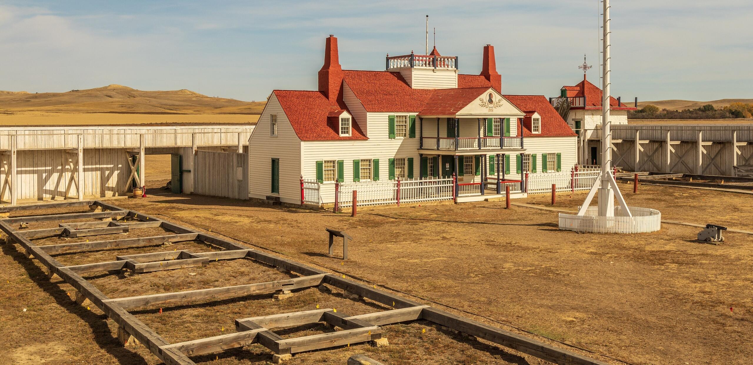 photo of the trading Post, a white building with a red roof and green window shutters
