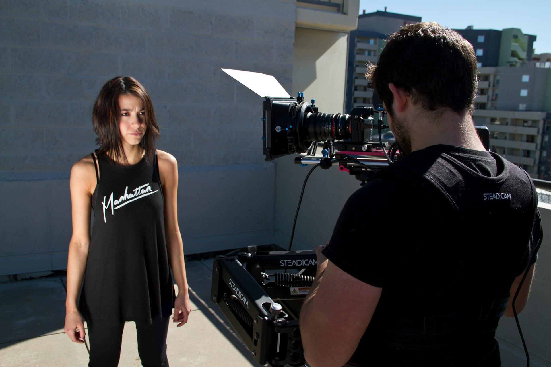 Actress preparing for a filmed scene while a camera operator records her performance