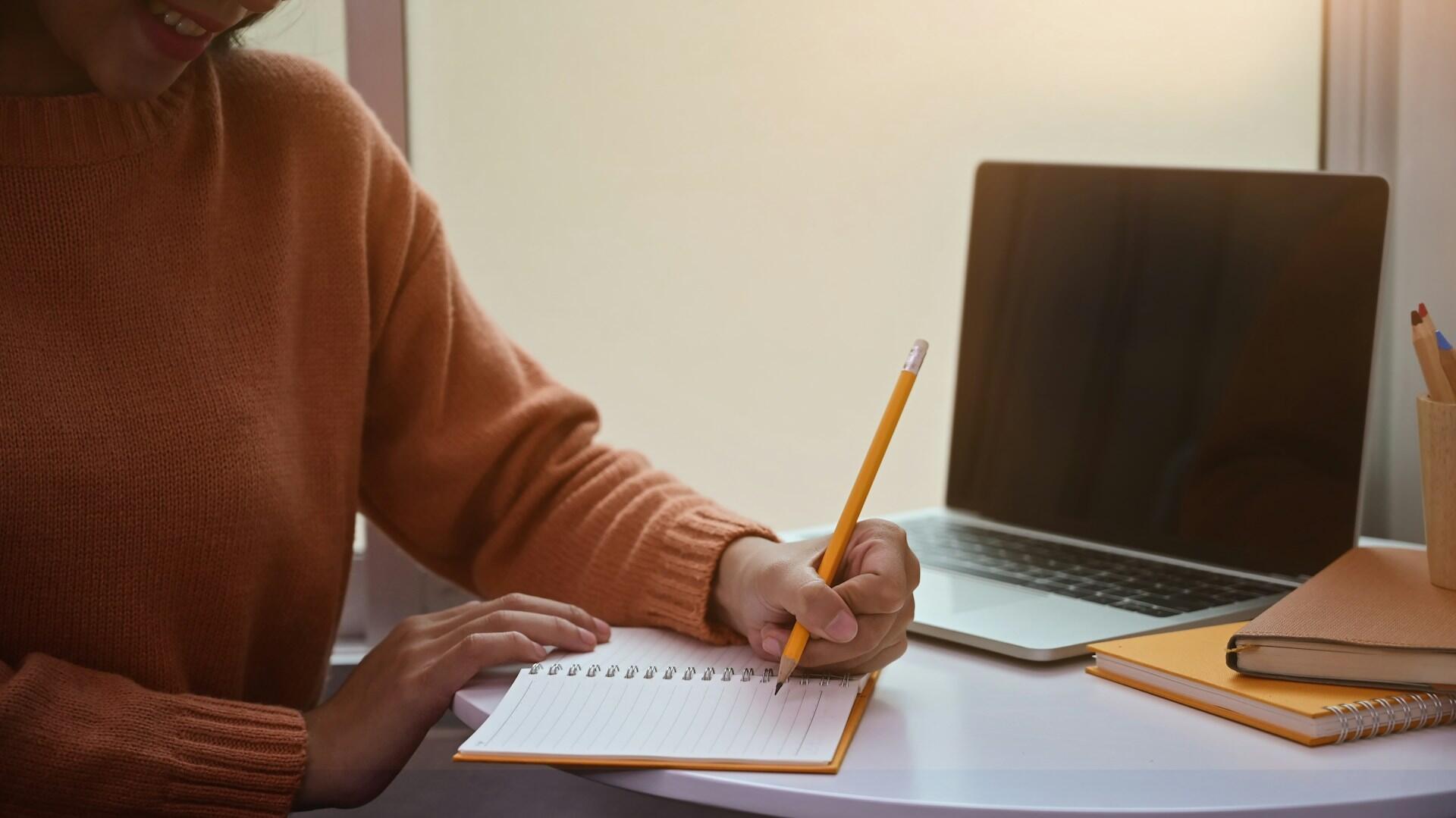 student practicing handwriting essays in a notebook