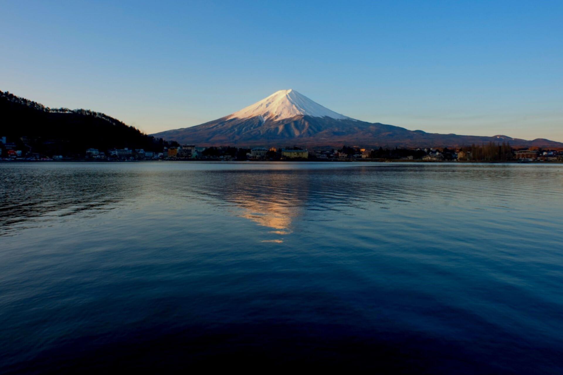 Mount Fuji viewed across Lake Kawaguchi during summer with clear skies and mountain reflection on the water