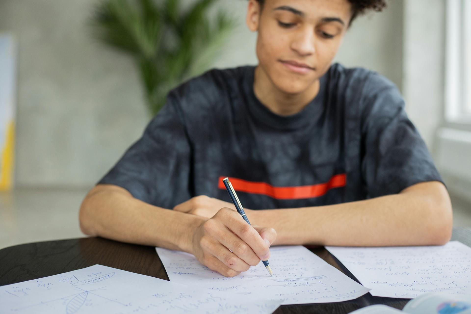 student writing on paper at a desk