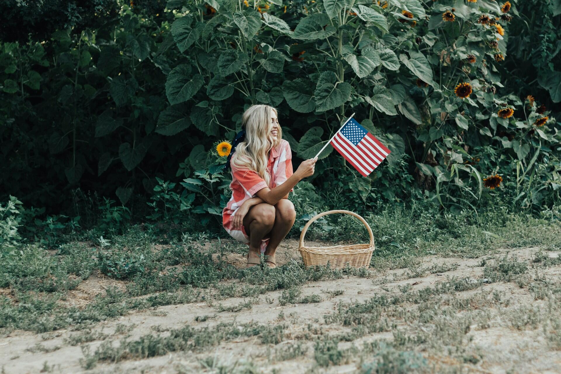 Woman hiding items in a patriotic scavenger hunt in the backyard