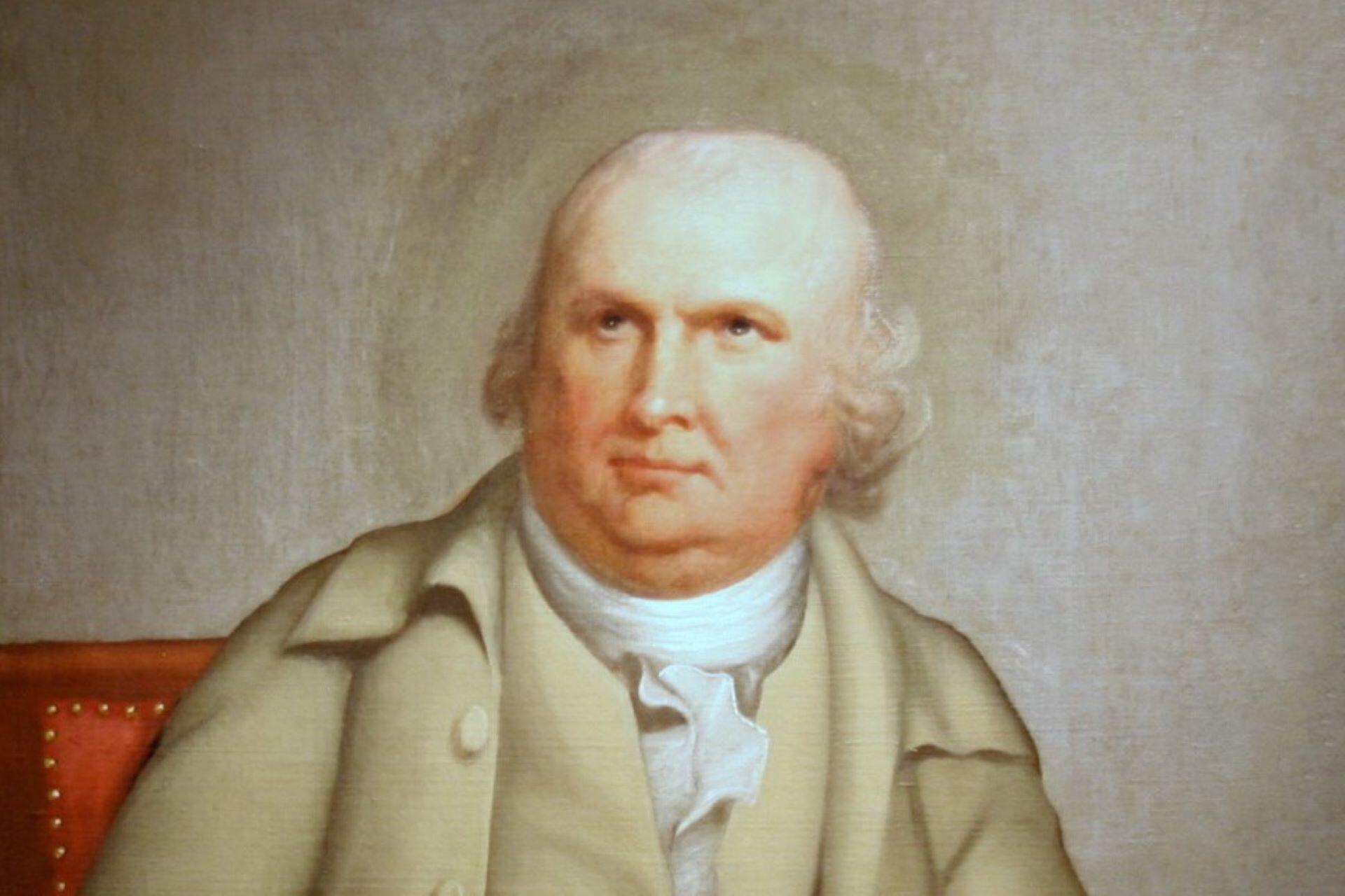 Portrait of Robert Morris seated in a pale coat with a red chair behind him.