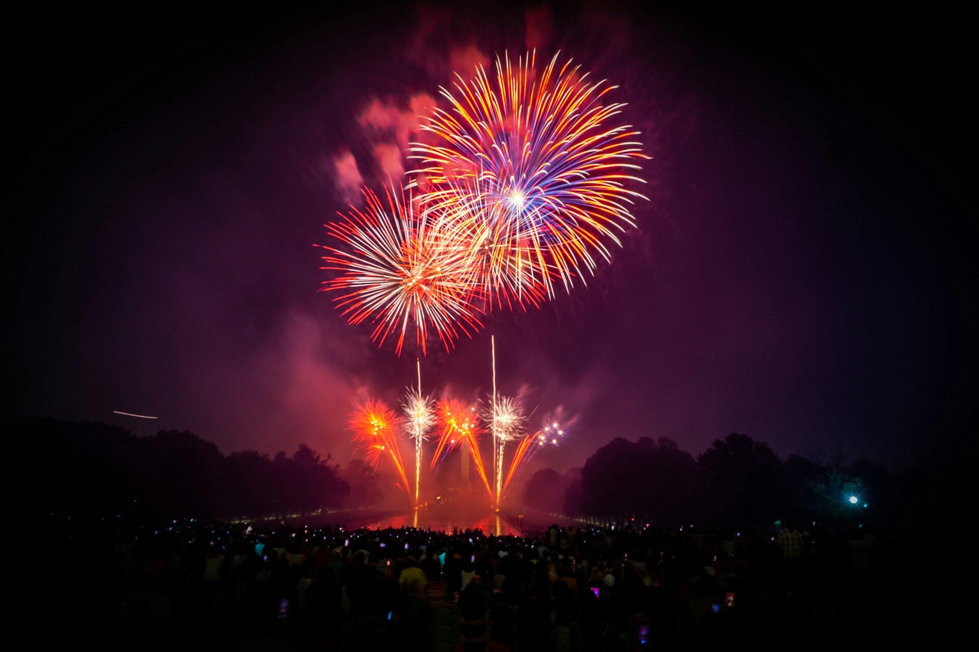 Fireworks over a crowd at a Fourth of July outdoor celebration