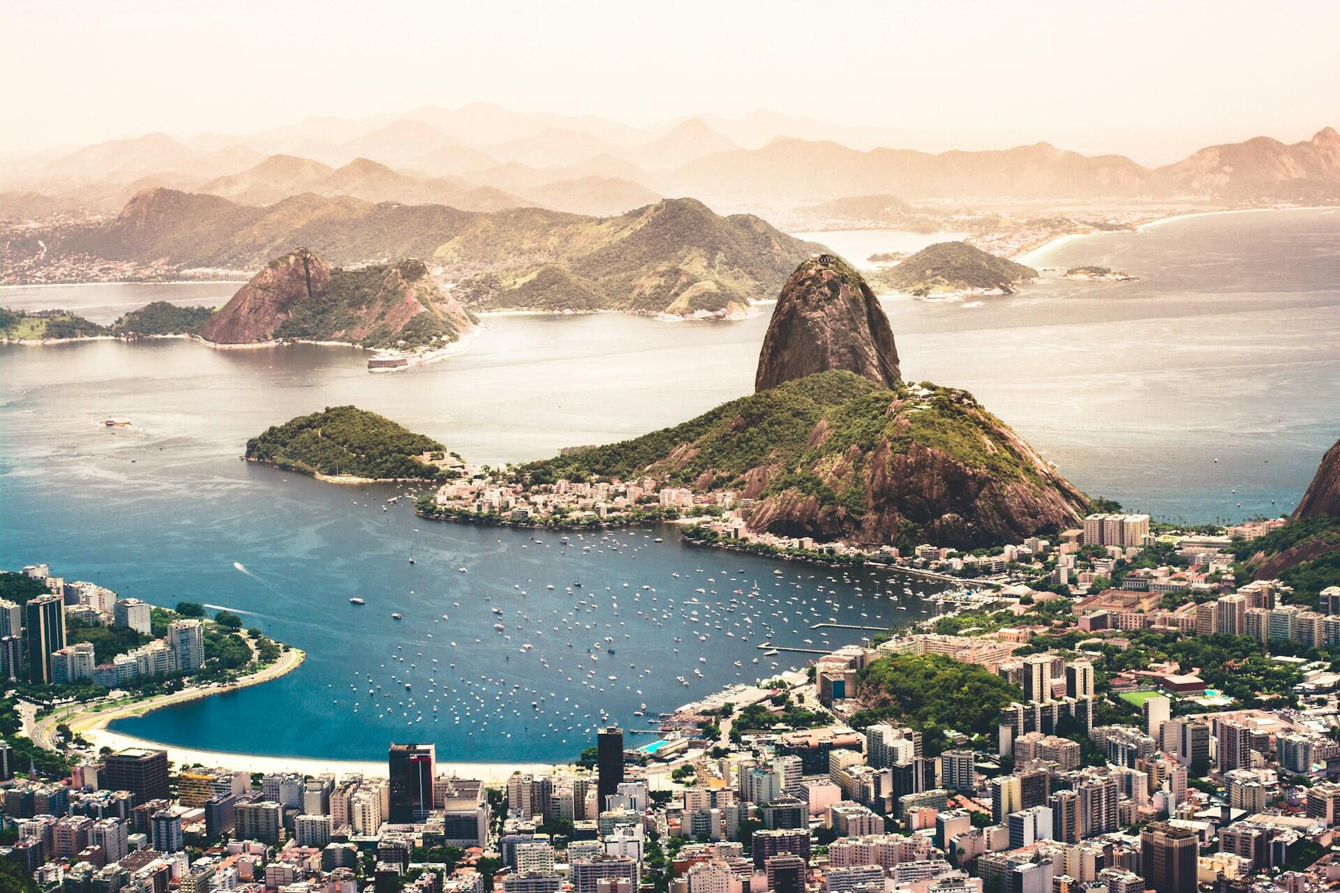 Aerial view of Rio de Janeiro with mountains, ocean, boats, and city buildings