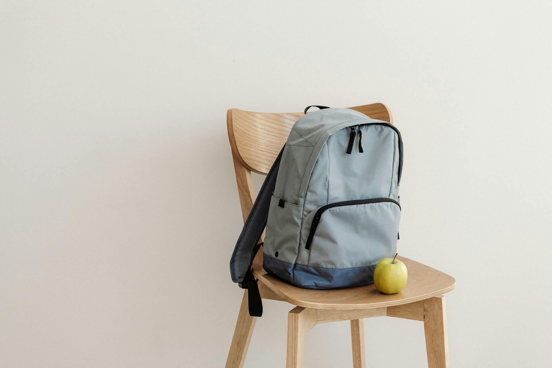 packed school bag on a chair with an apple