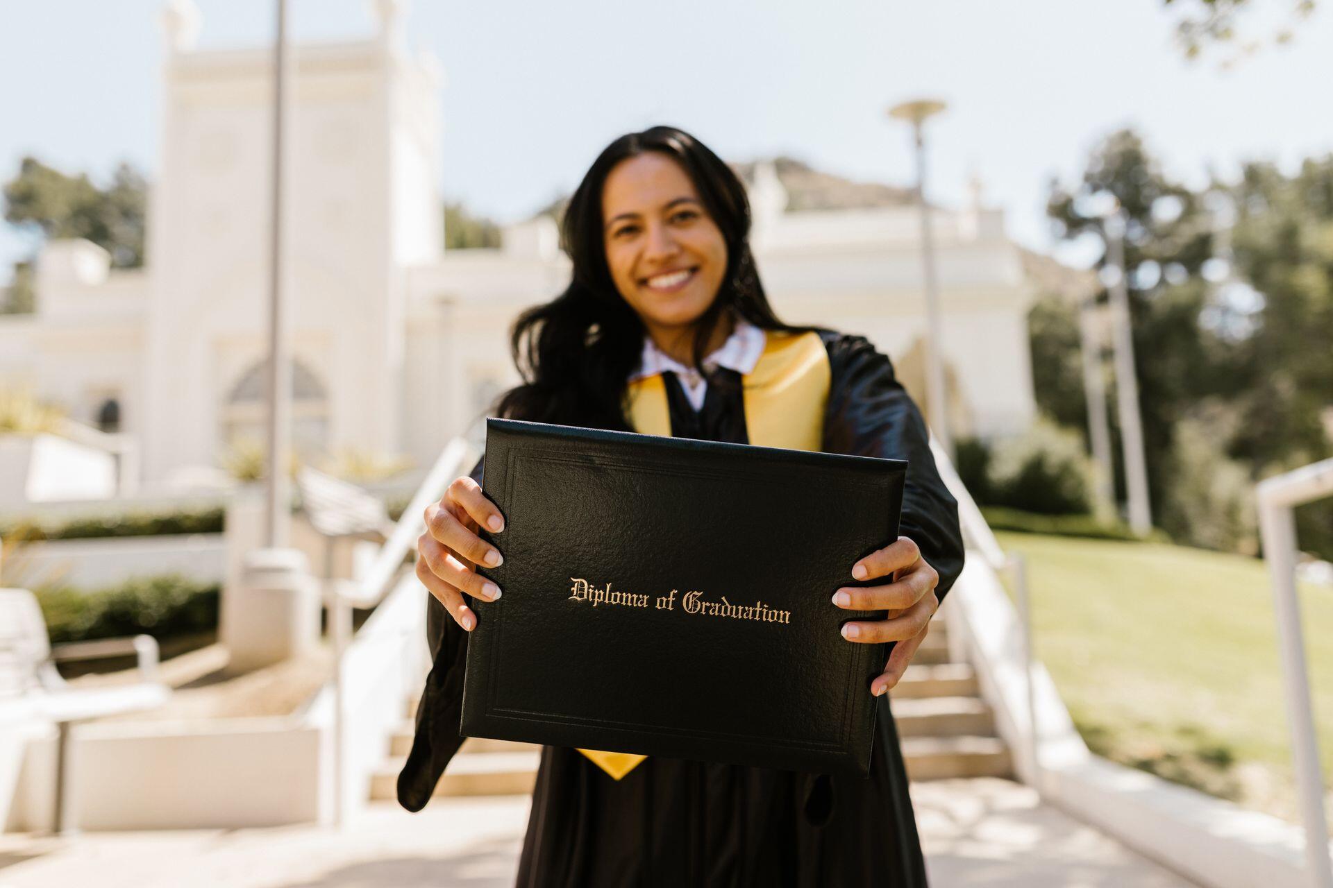 law school graduate proudly holding up their diploma