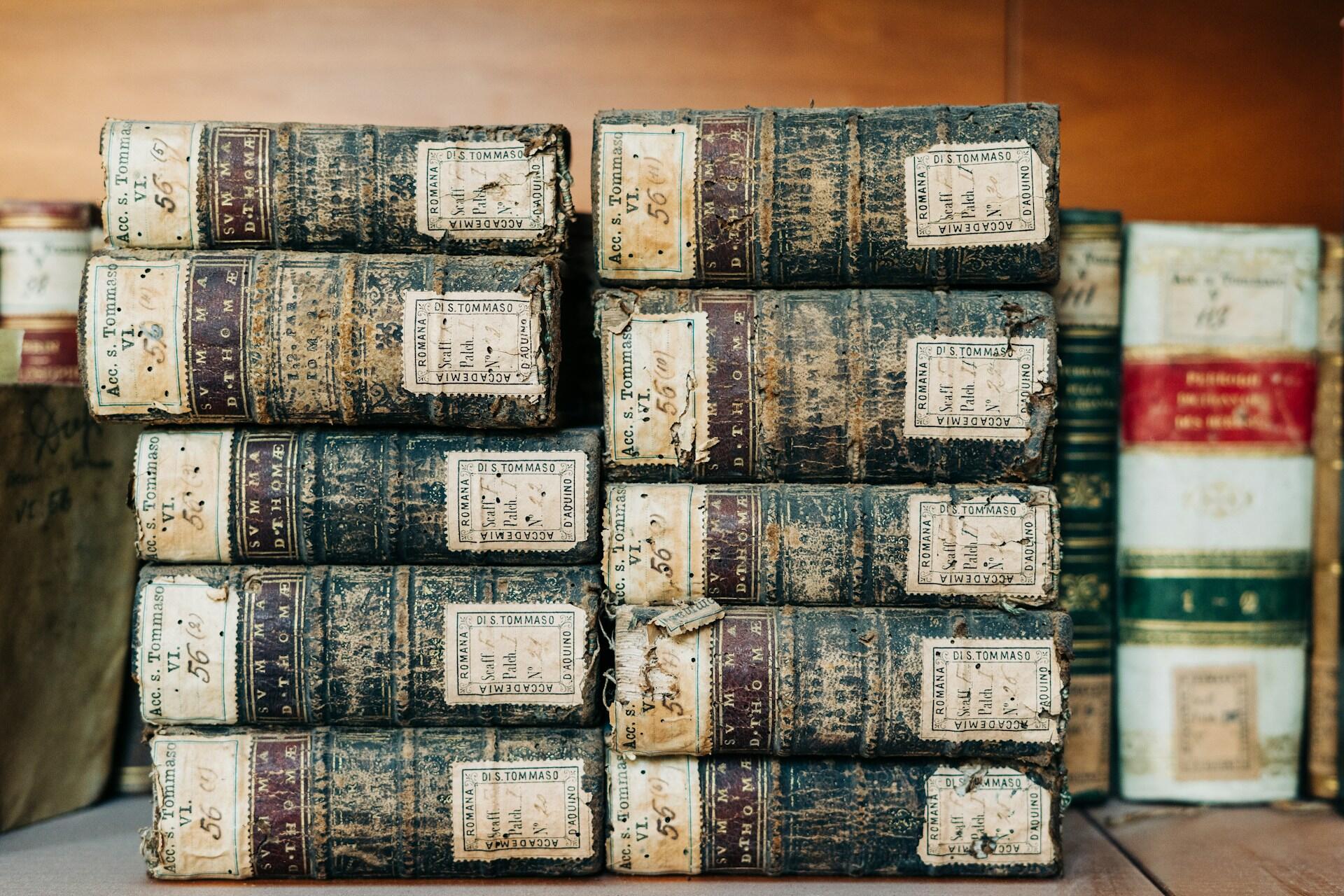 10 old books stacked side by side in two stacks of five.