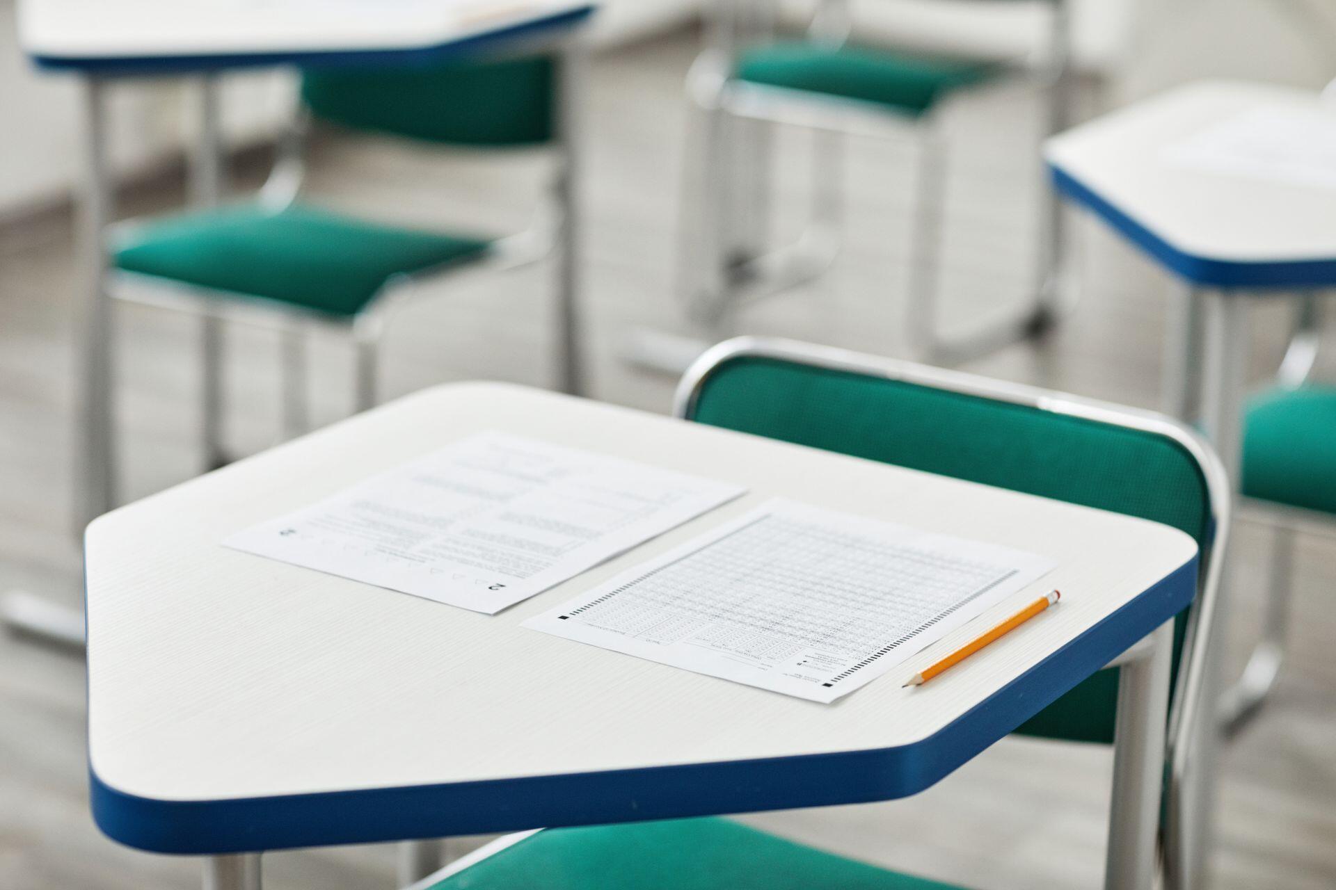 a school desk with two sheets of standardized test paper placed on top