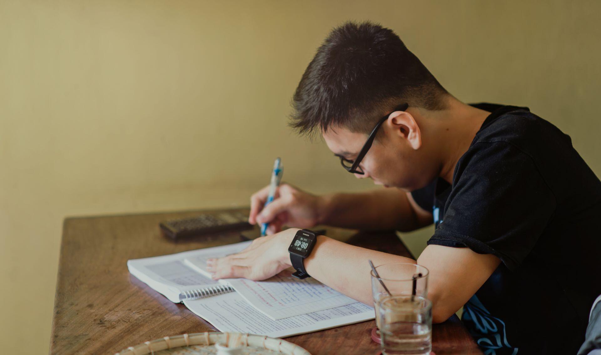 student using a booklet and test prep textbook to study