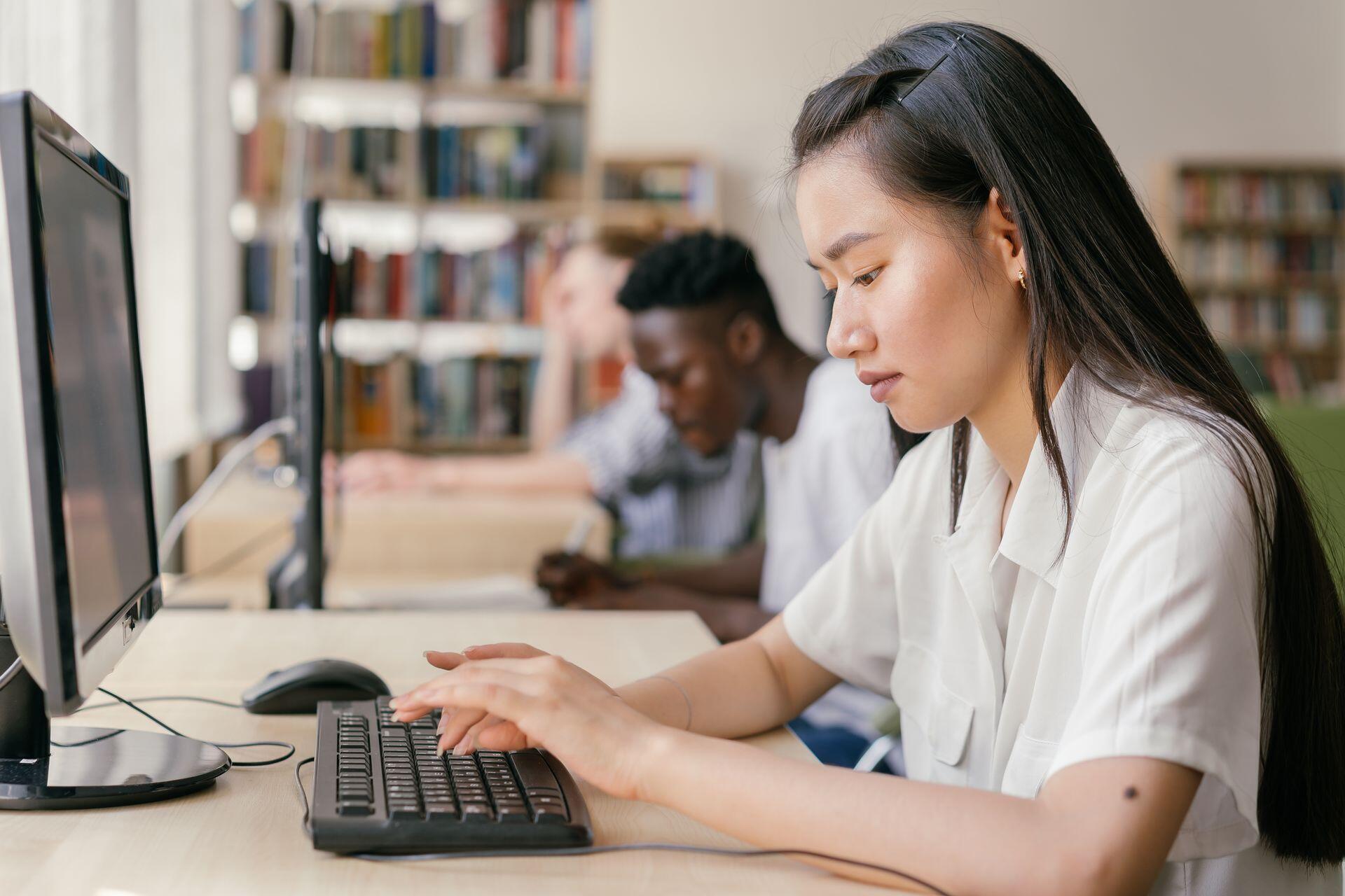 students taking a test on the computer in a well-lit classroom