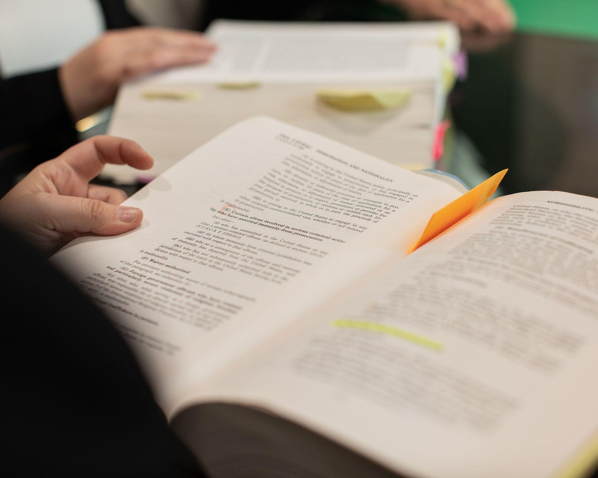 law student reading from and highlighting in a textbook