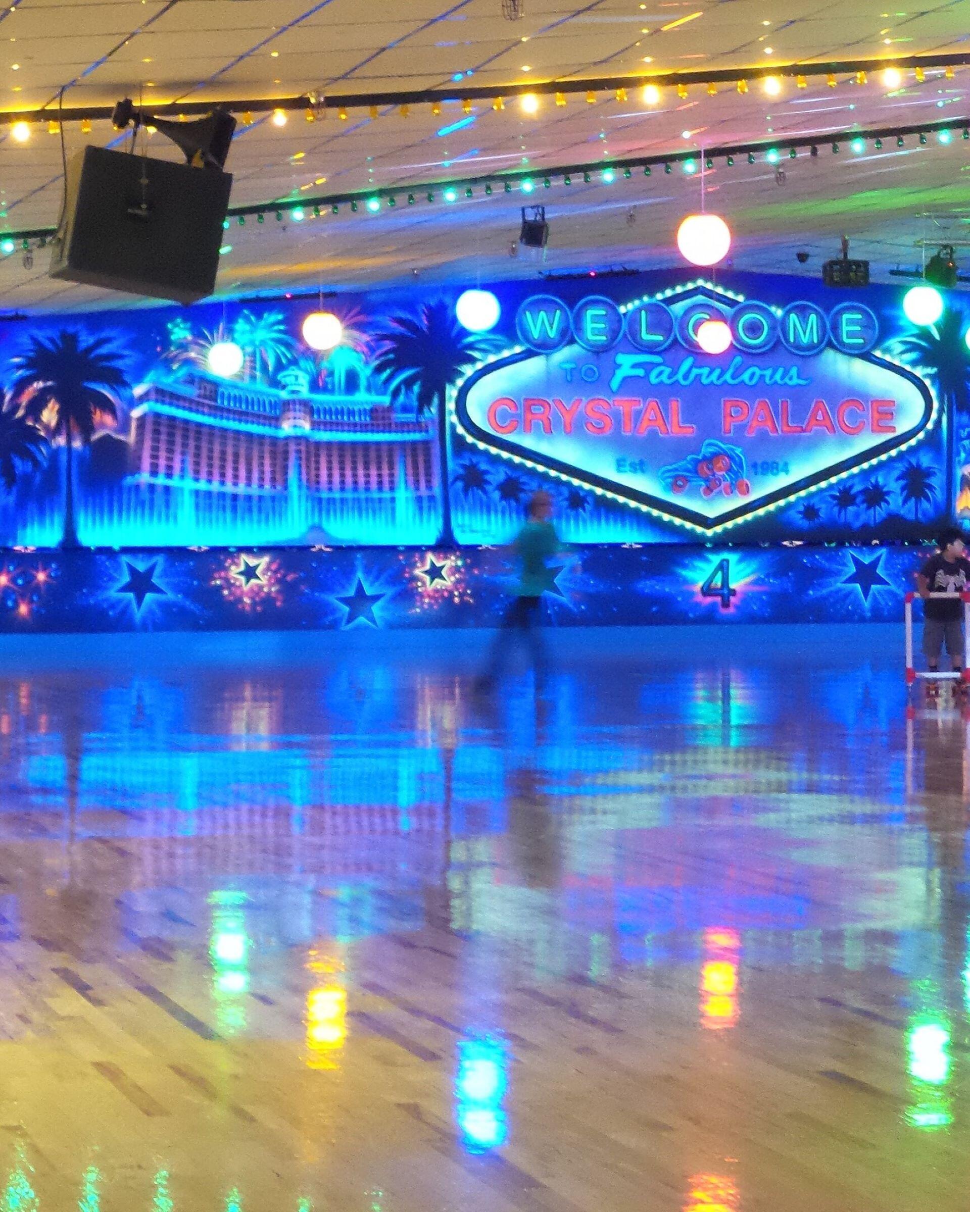 Indoor Crystal Palace skating rink with colorful lights and a large Crystal Palace sign