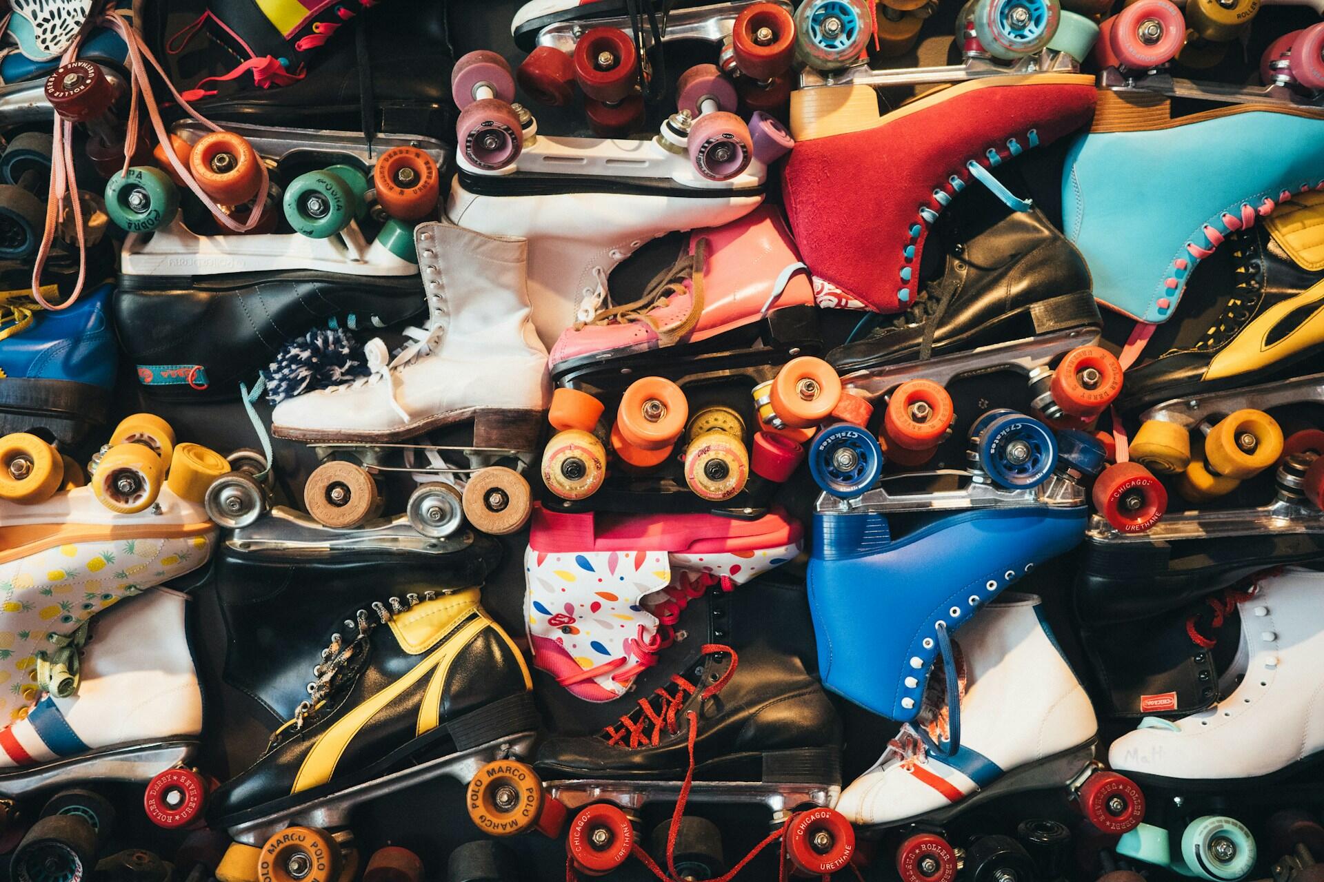 Assortment of colorful quad roller skates piled together