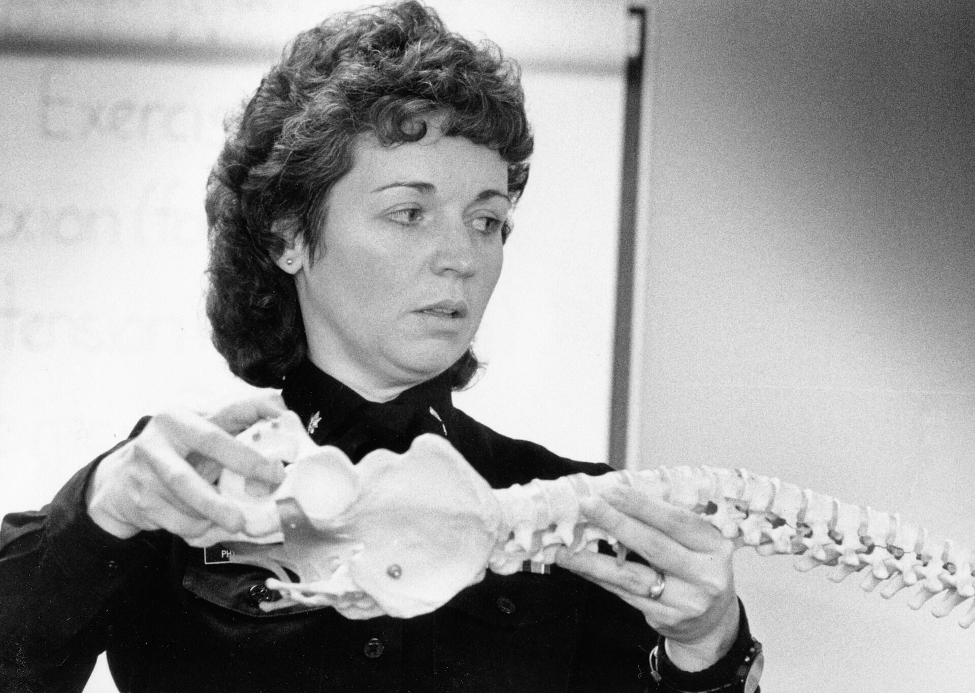 Foto antiga de estudante durante aula de anatomia.