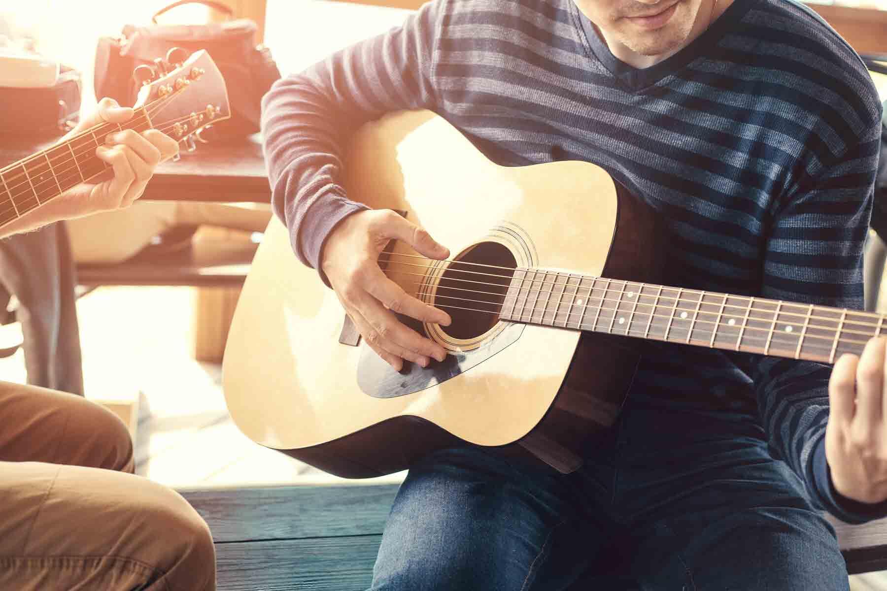 A student taking guitar lessons.