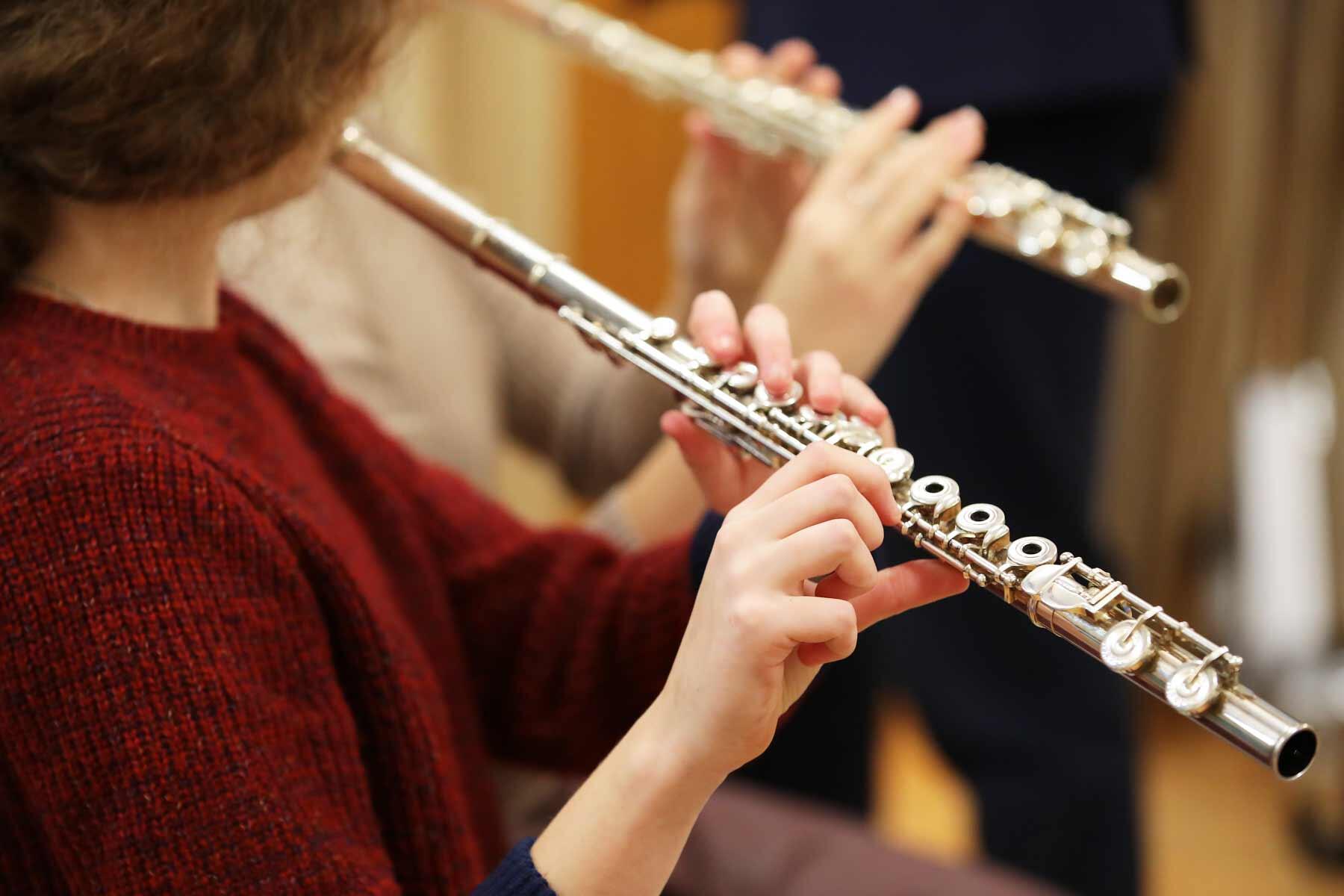 A young girl taking flute lessons.