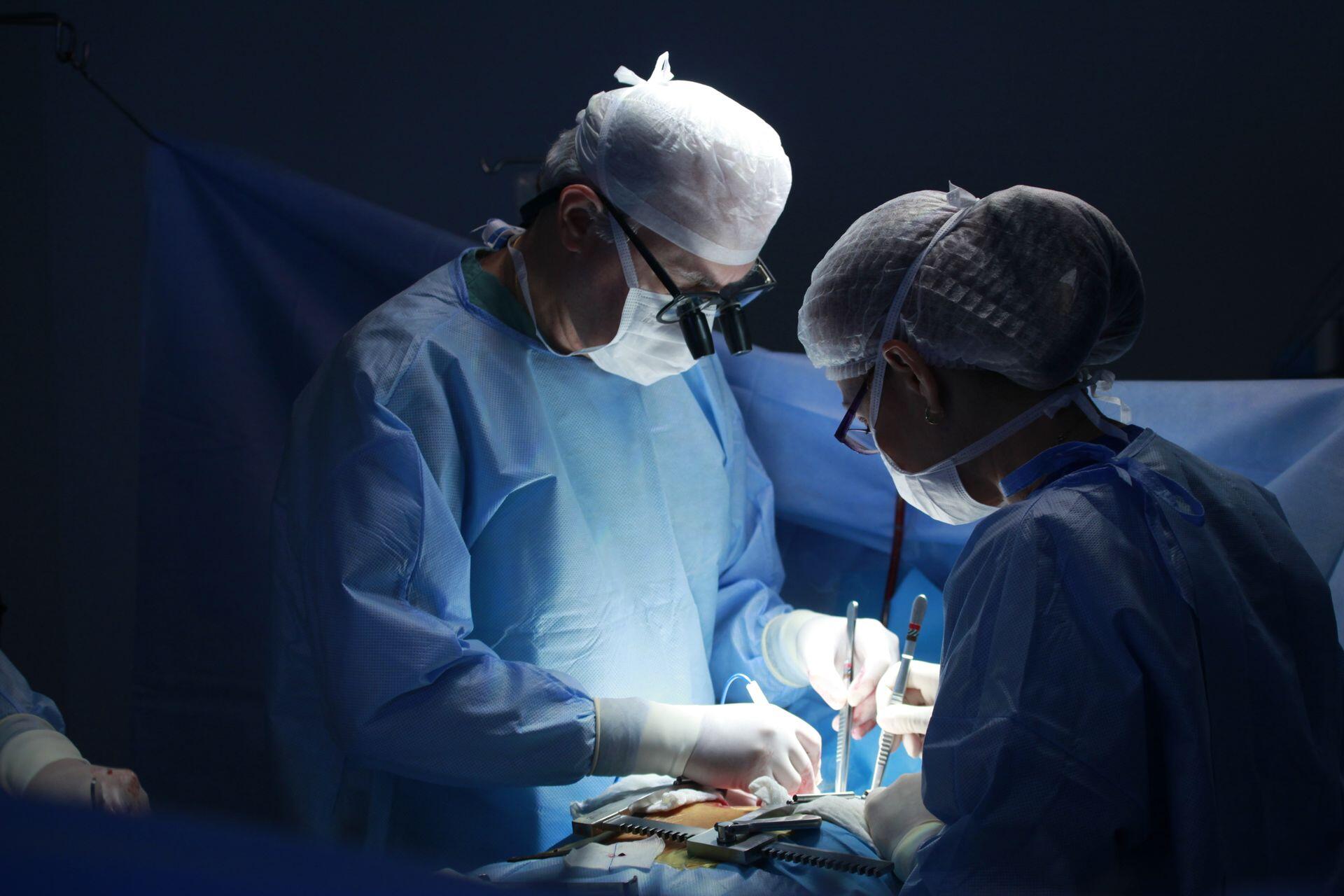 surgeons in an operating room performing surgery on a patient
