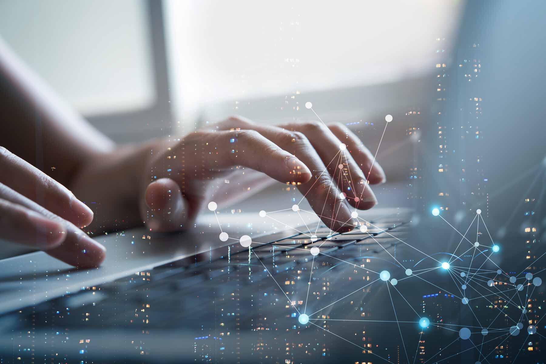 Hands typing on a laptop keyboard with a glowing network diagram overlaid