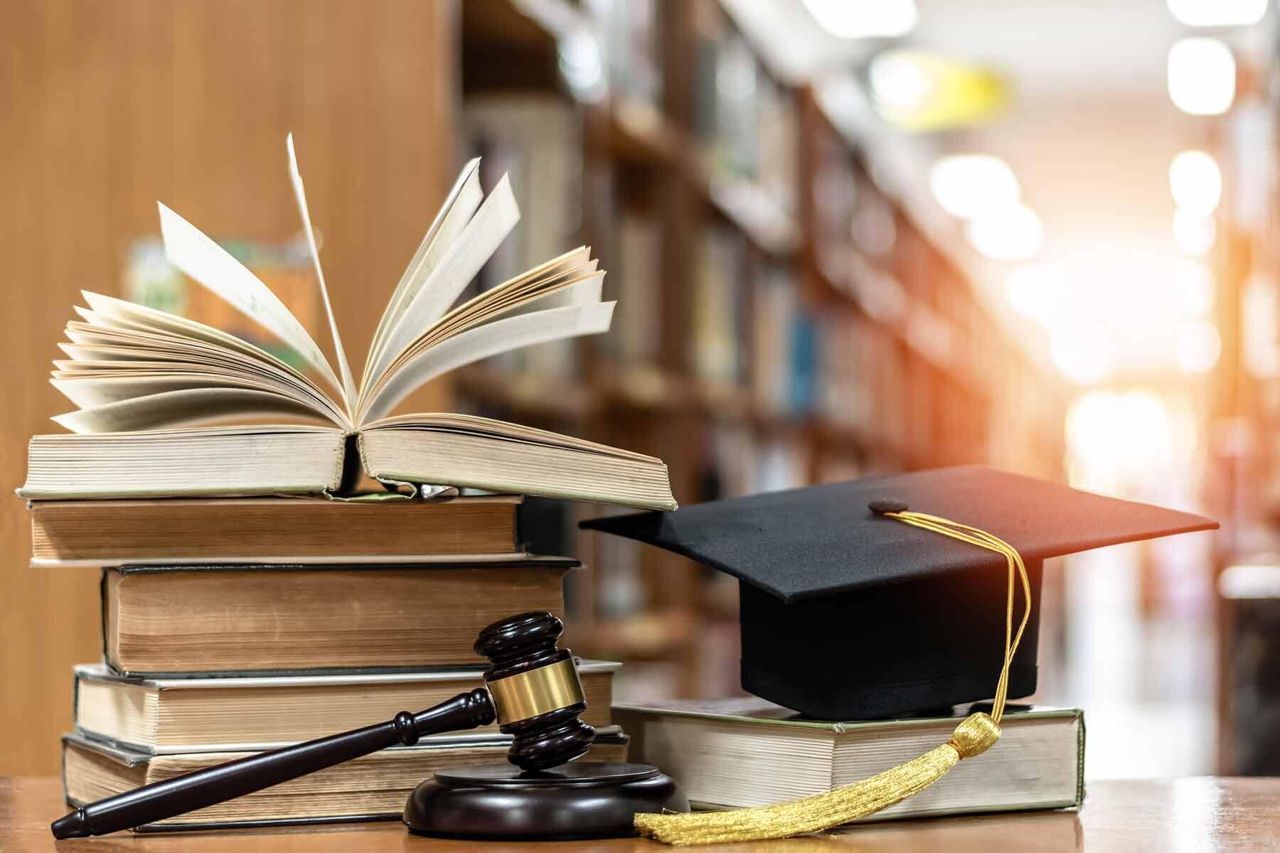 A judge's gavel with law school books and a graduation cap