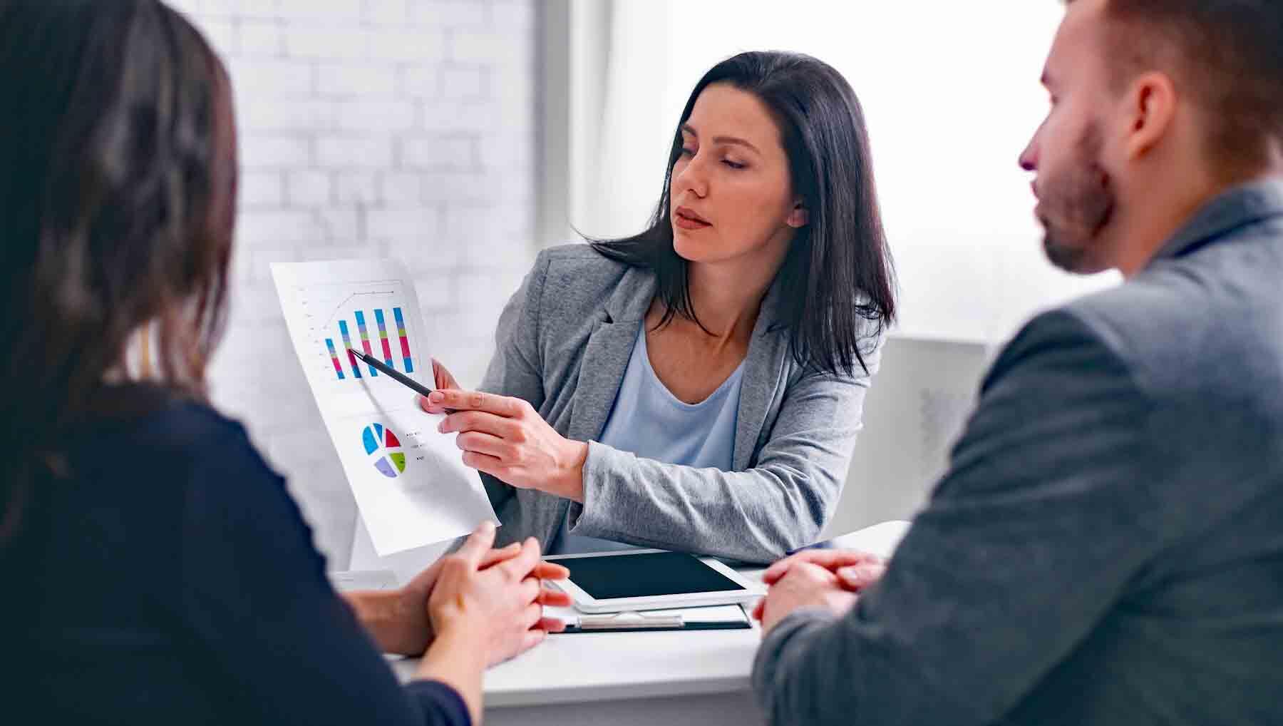 An investment broker showing a financial plan to clients