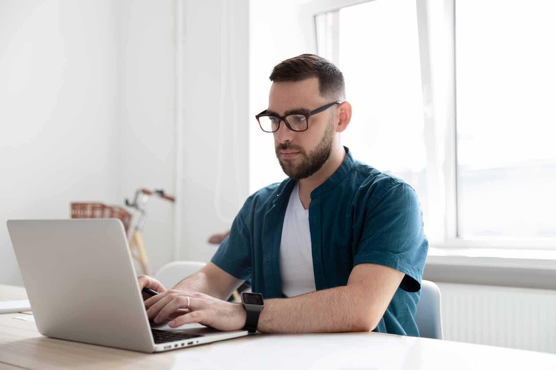 A man taking the GRE at-home test on a laptop computer