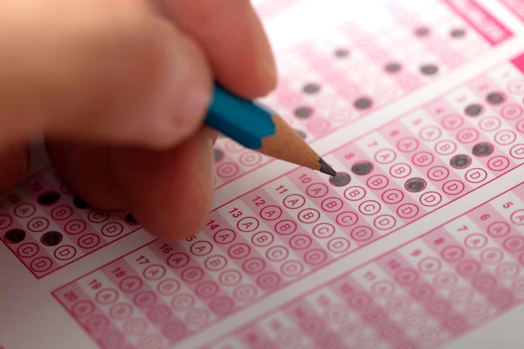 tutors-student-hand-with-pencil-filling-in-test-answer-sheet