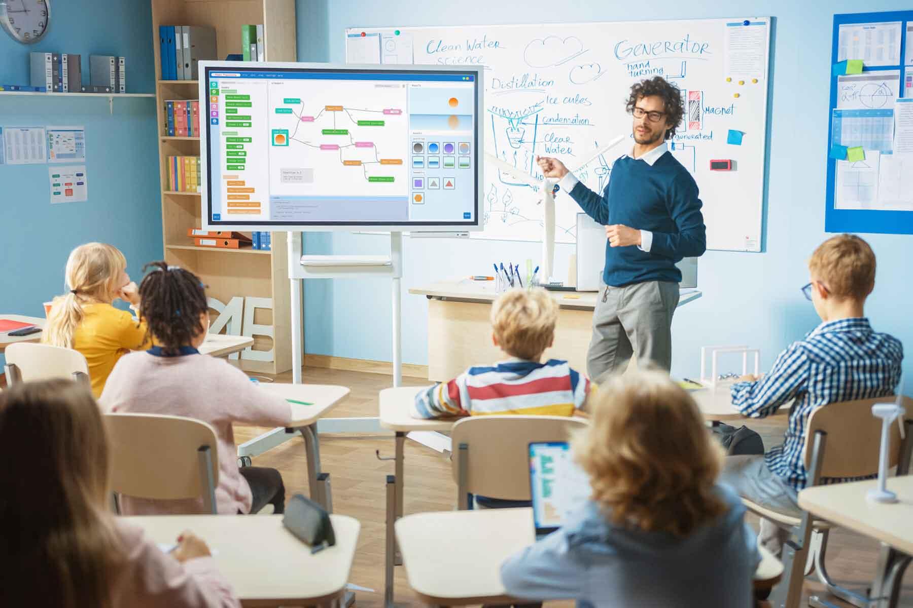 A teacher using a smart board in a classroom.