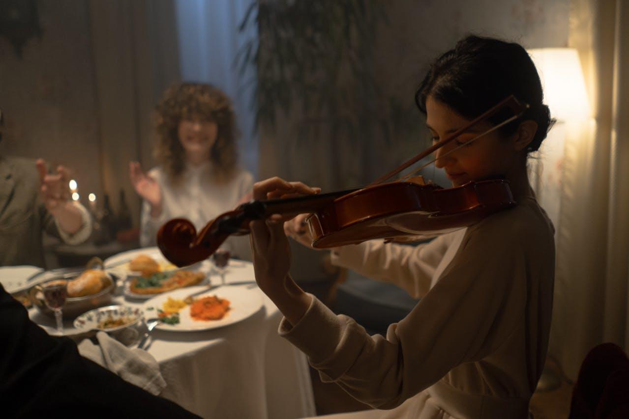 Mujer tocando el violin en una cena