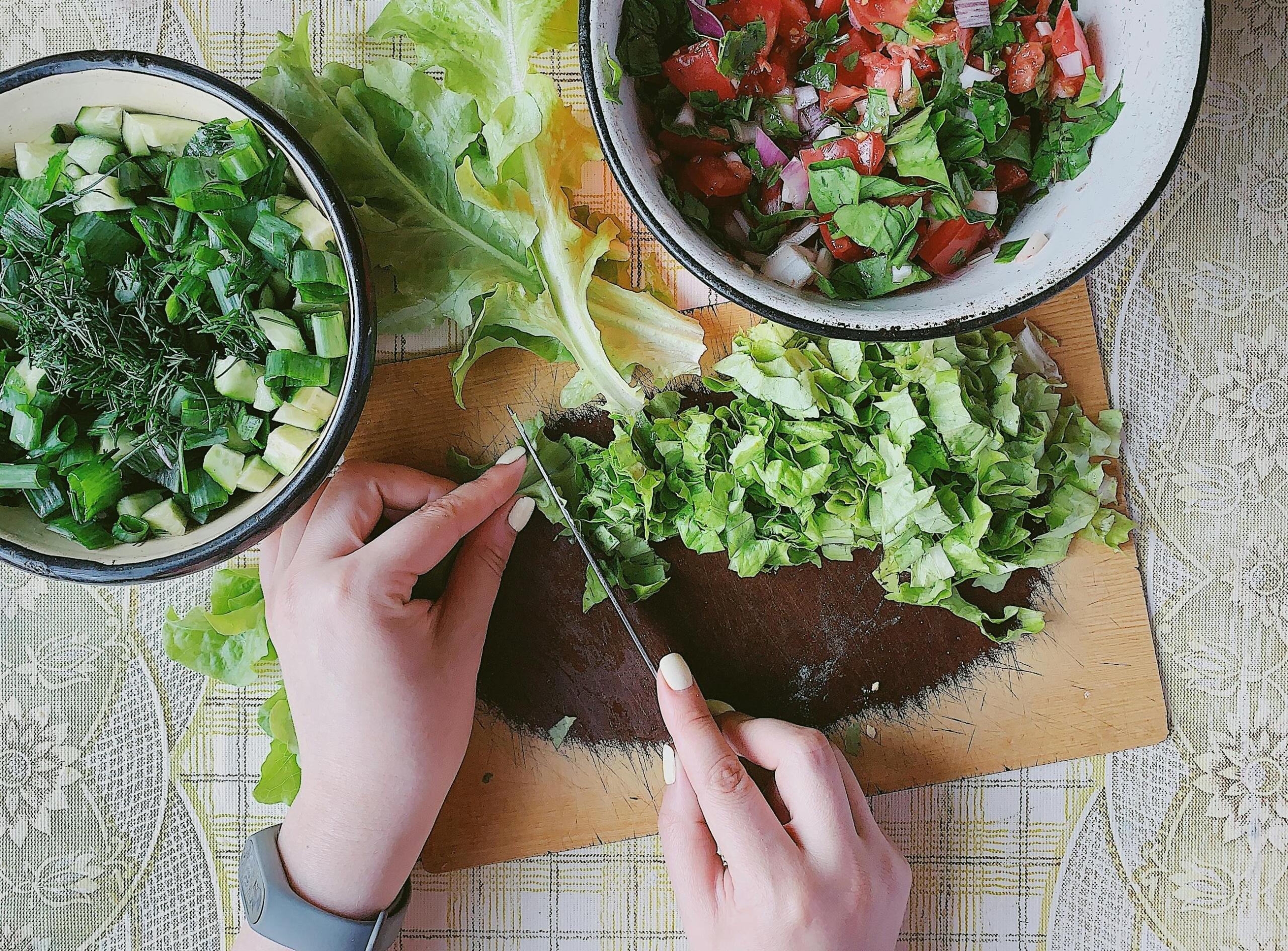 Manos preparando una ensalada