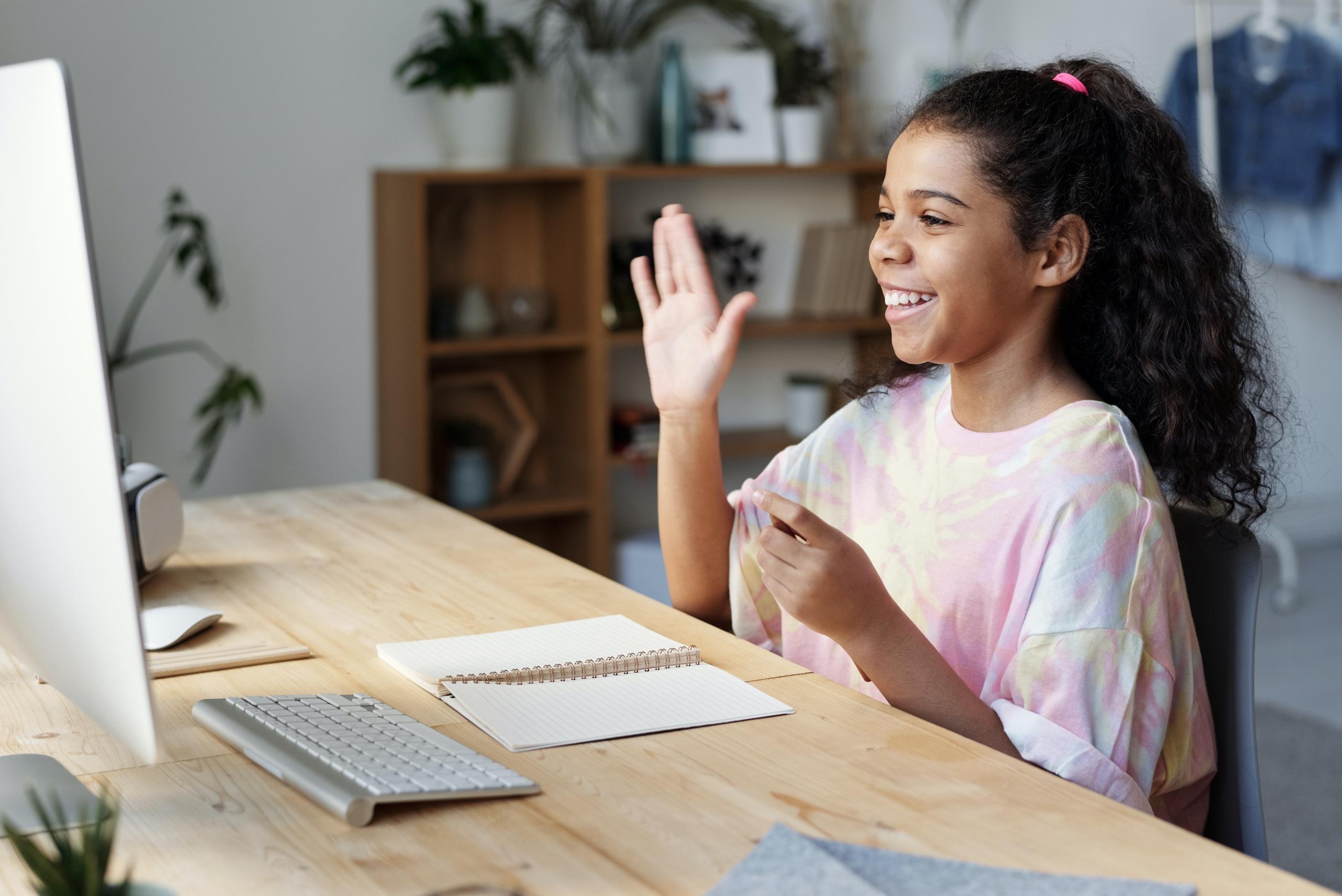 Niña saludando a una pantalla