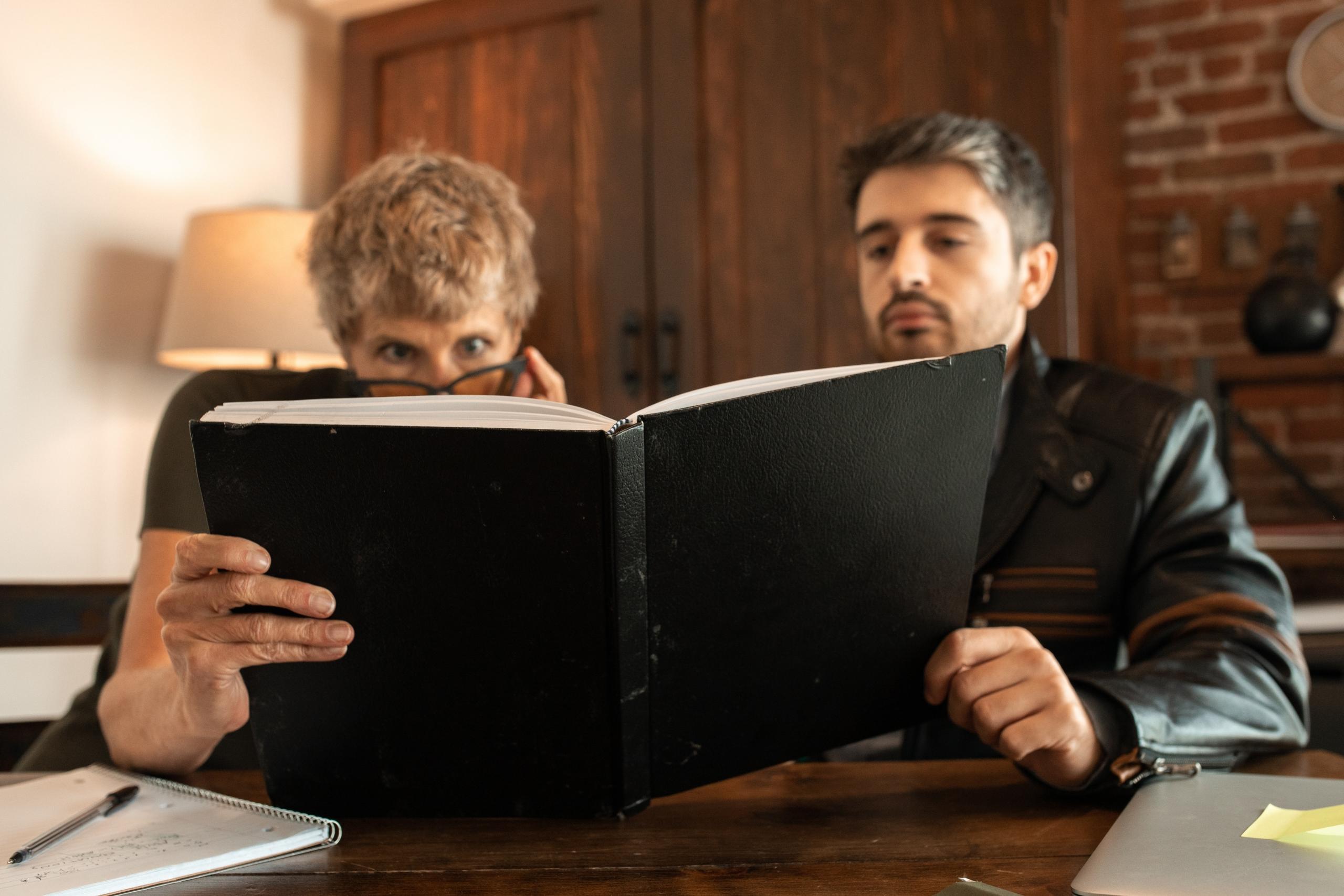 dos adultos viendo un cuaderno