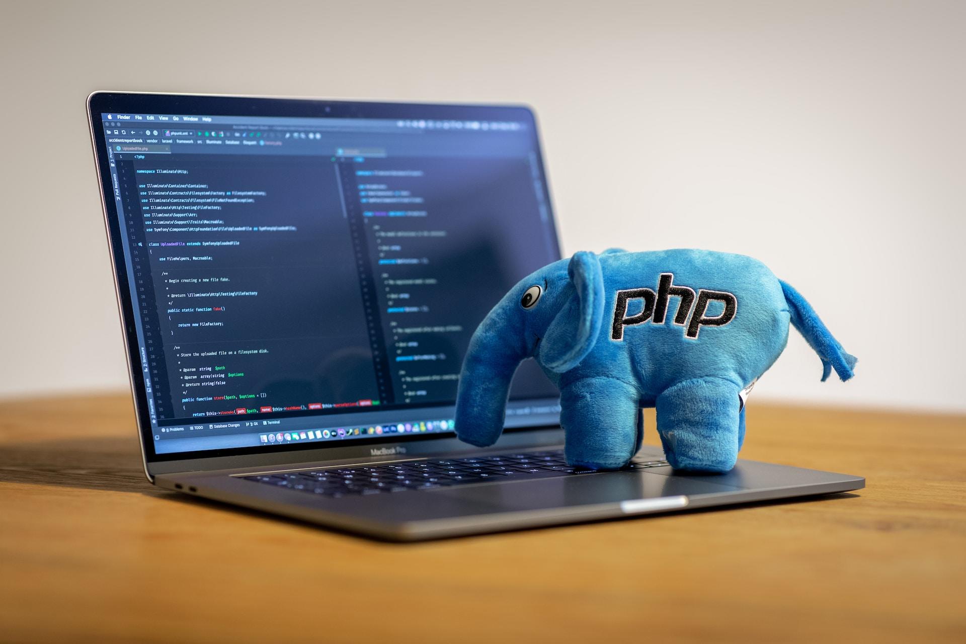 Computadora en un programa de programación, junto con elefante peluche.