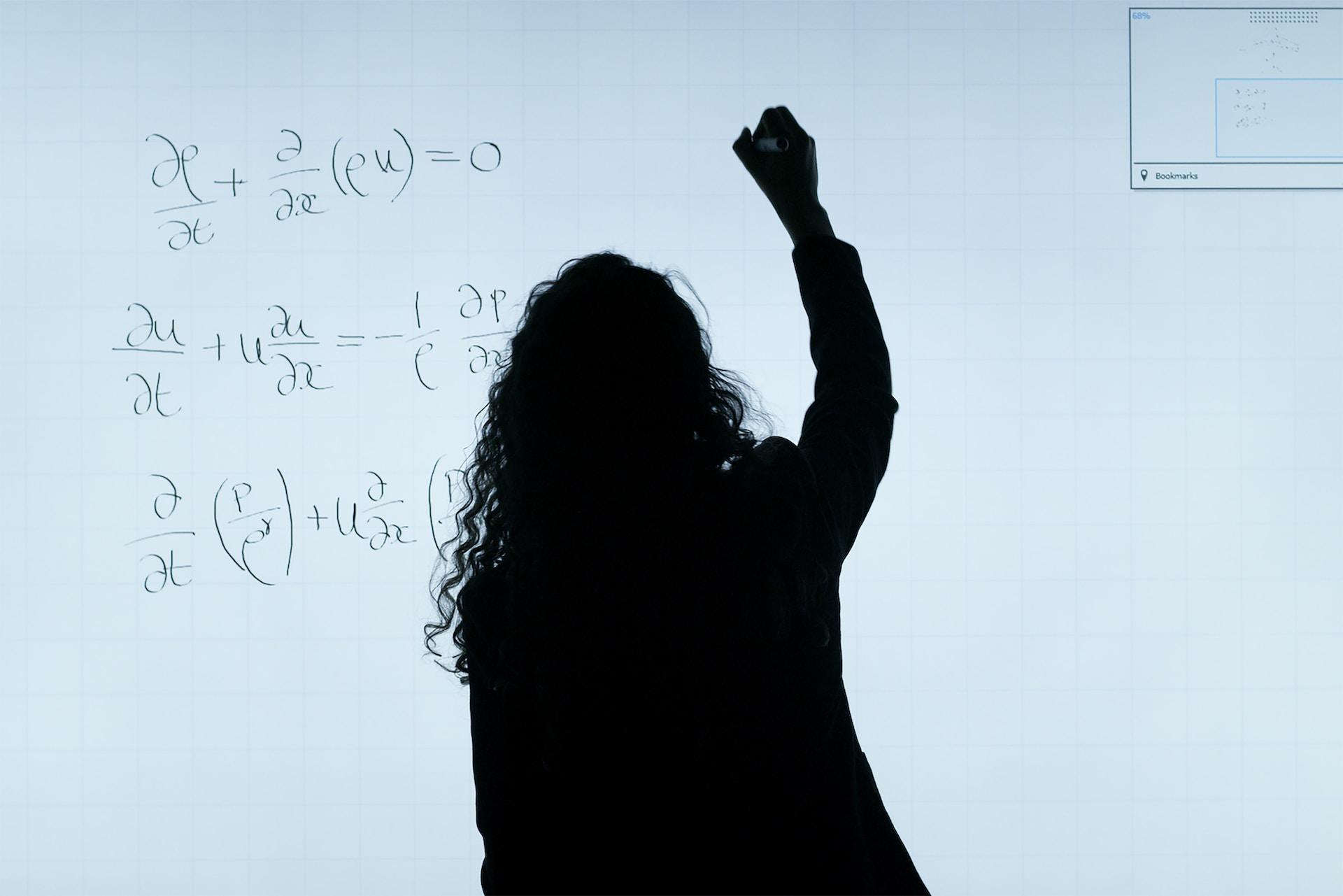 Profesora escribiendo en el pizarron