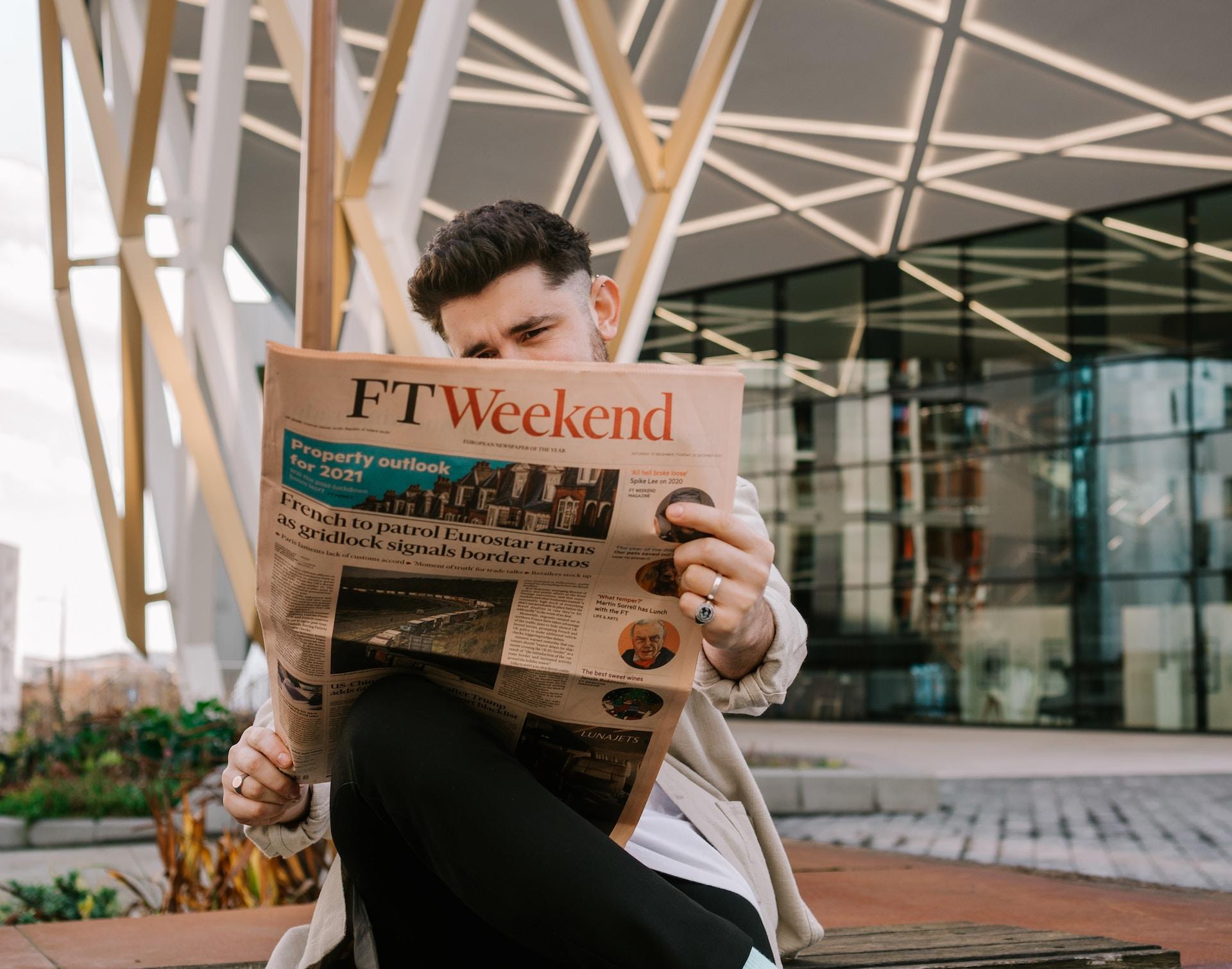 Joven leyendo un diario en inglés