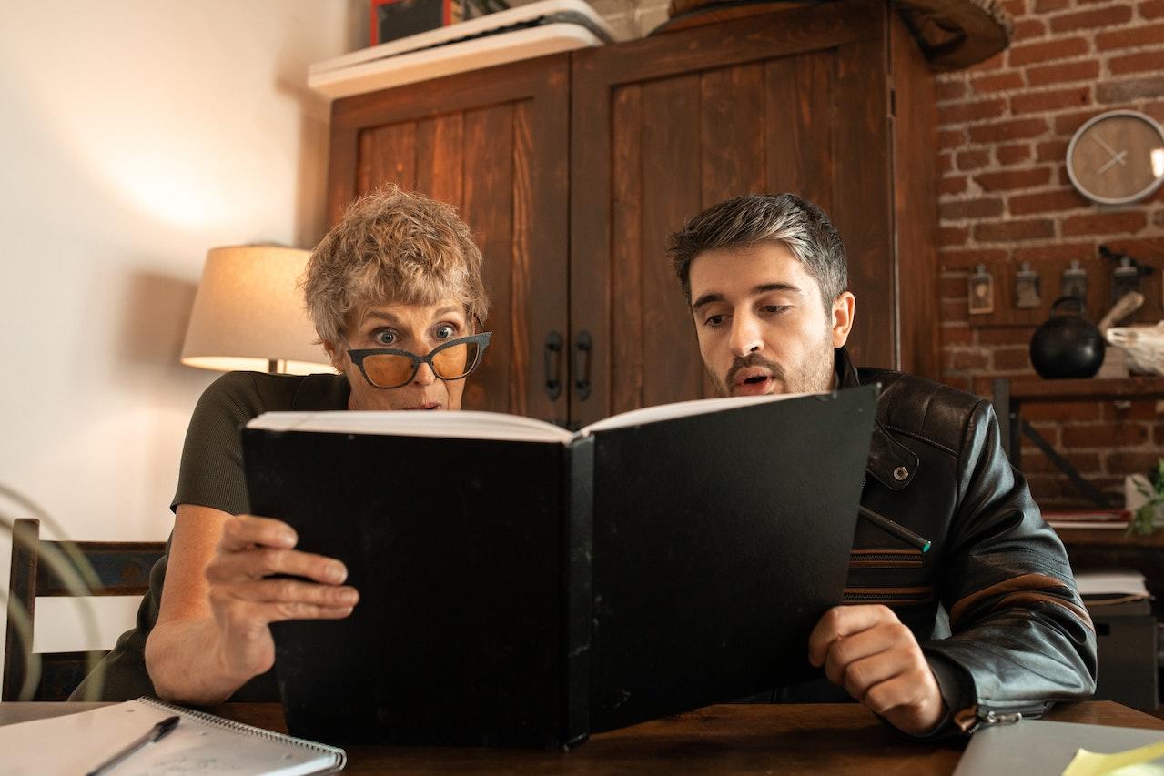 Dos personas frente a un libro de estudios