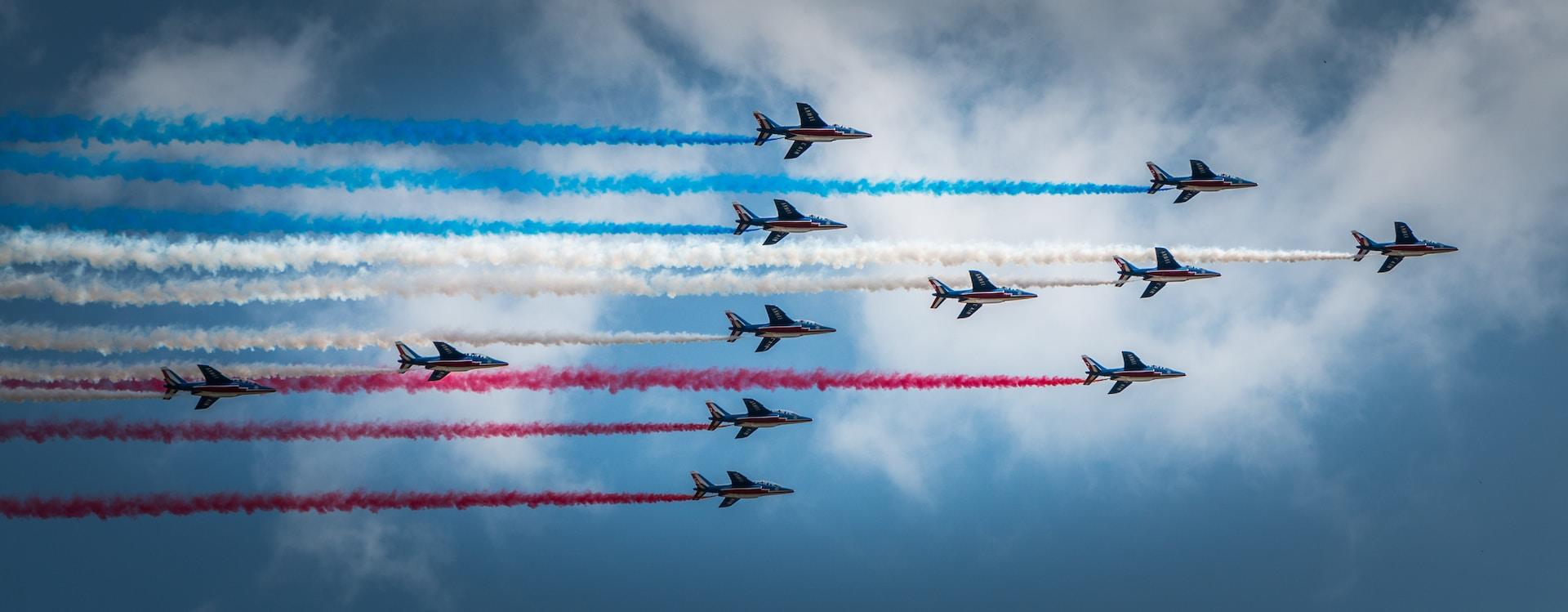 Aviones militares formando la bandera de Francia con humo de colores.