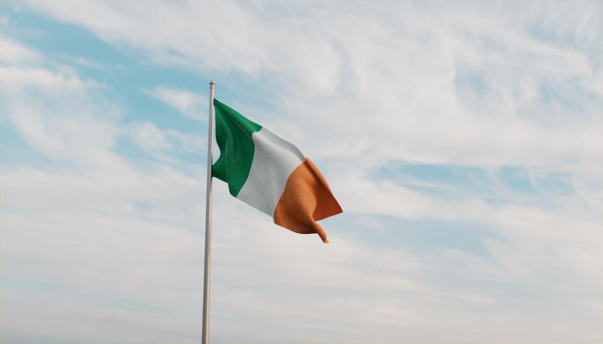 Bandera de la República de Irlanda sobre fondo con nubes