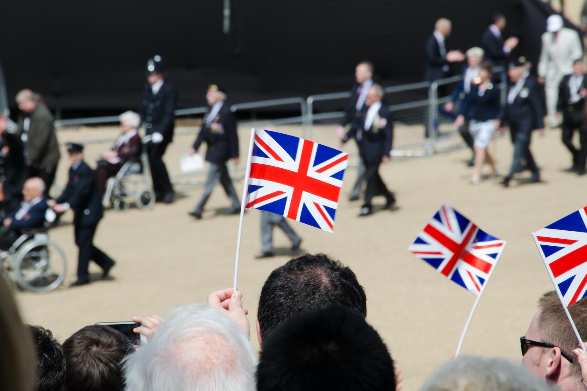 Personas ondeando la bandera británica en un desfile