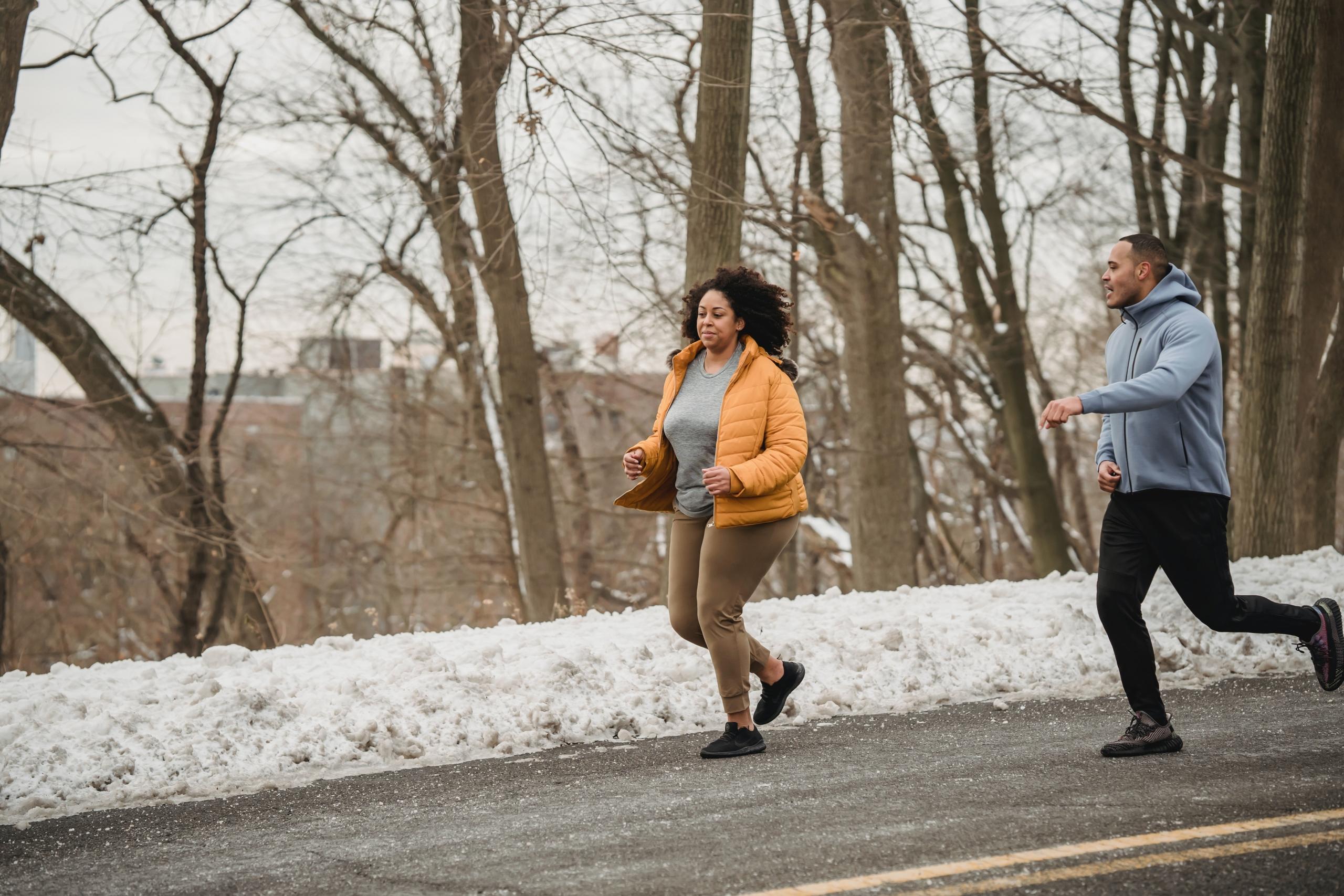 mujer corriendo junto a un entrenador personal
