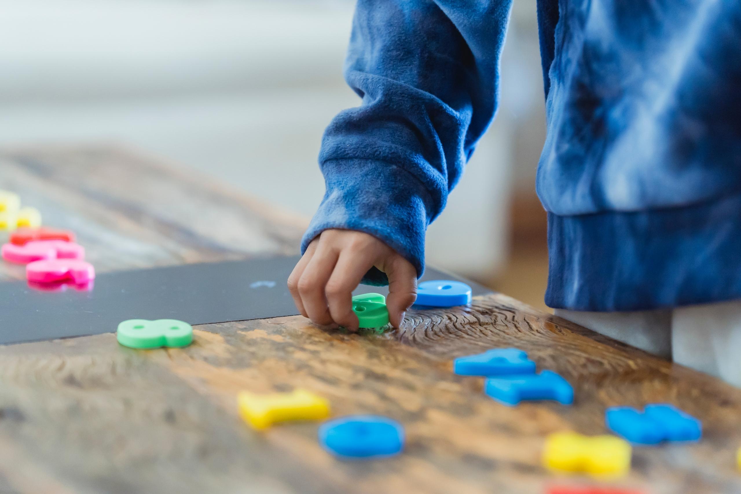 niño jugando con números de plástico