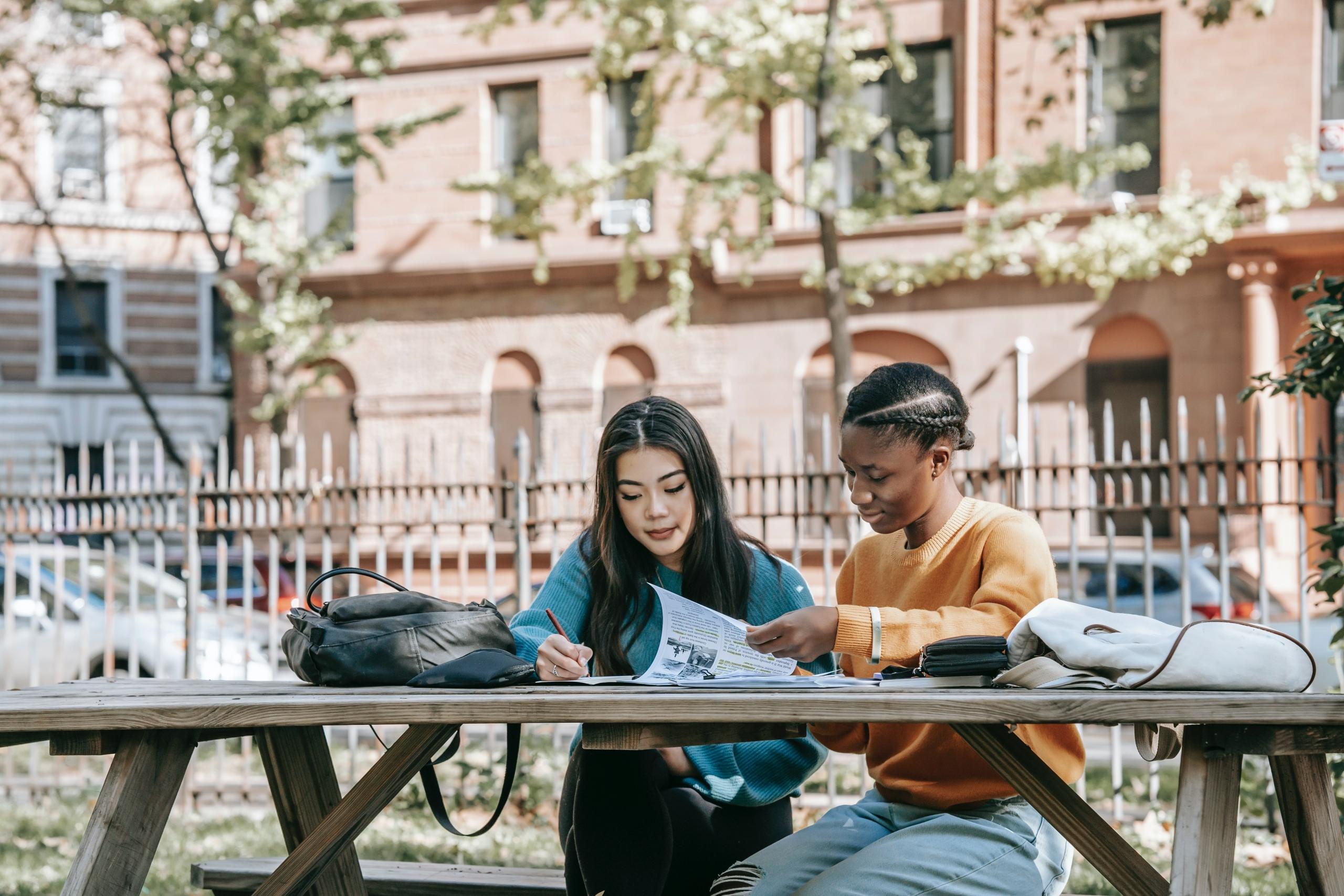 dos chicas estudiando juntas afuera