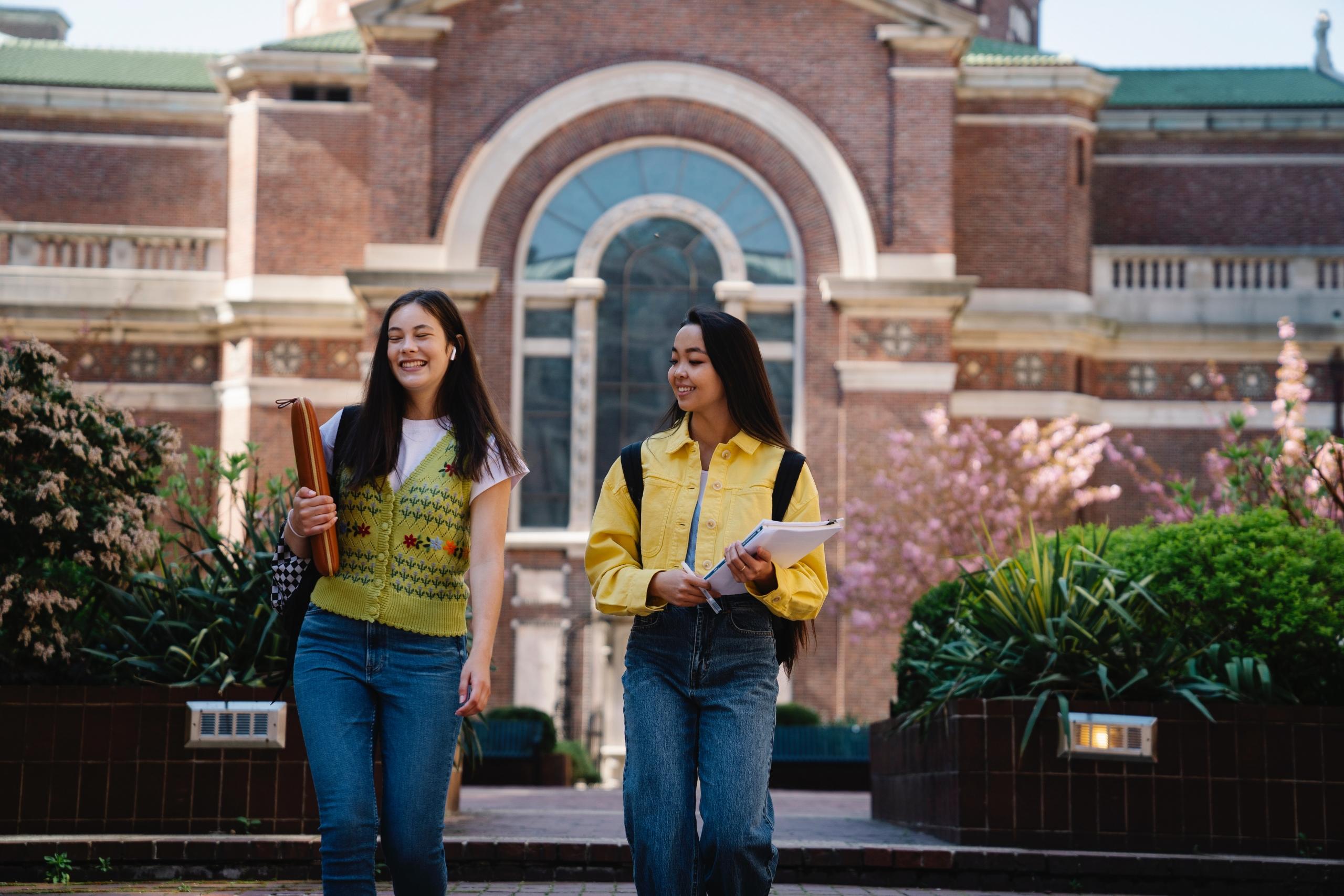 dos alumnas caminando fuera de una institucion academica