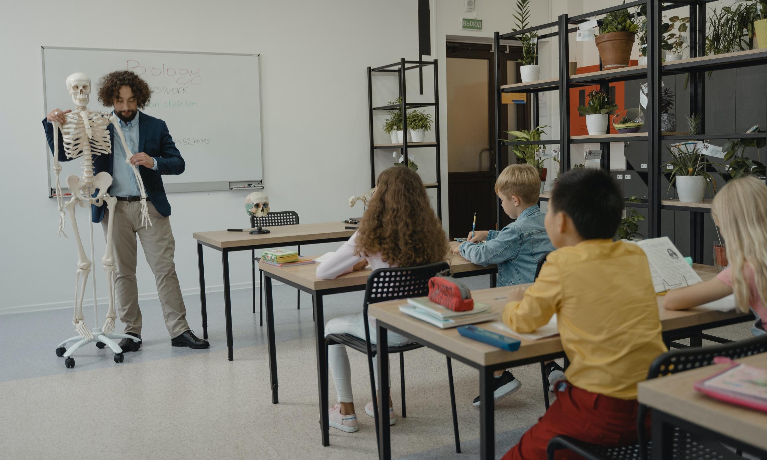 profesor con un esqueleto en un aula llena de chicos