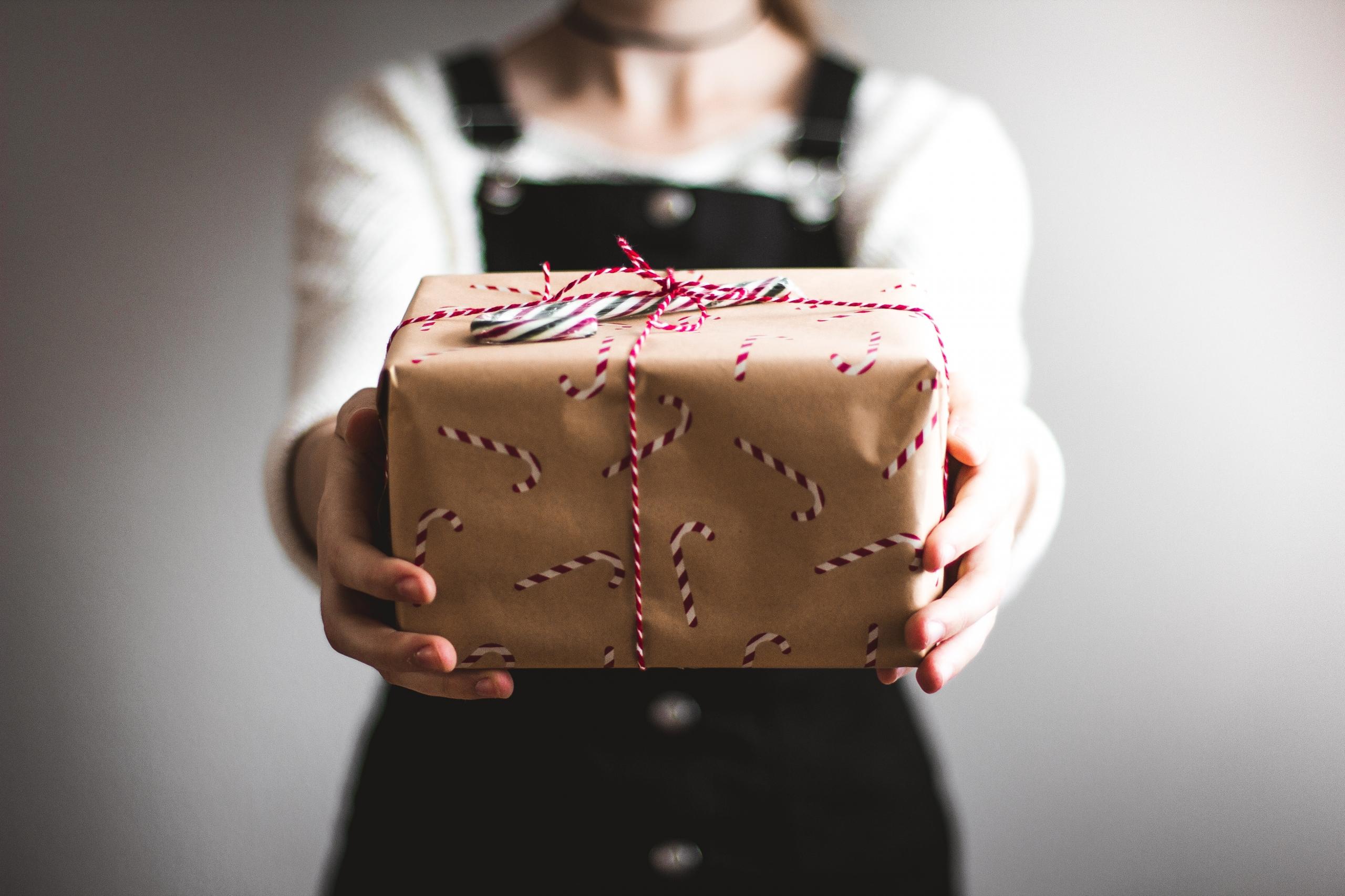 persona sosteniendo un regalo navideño
